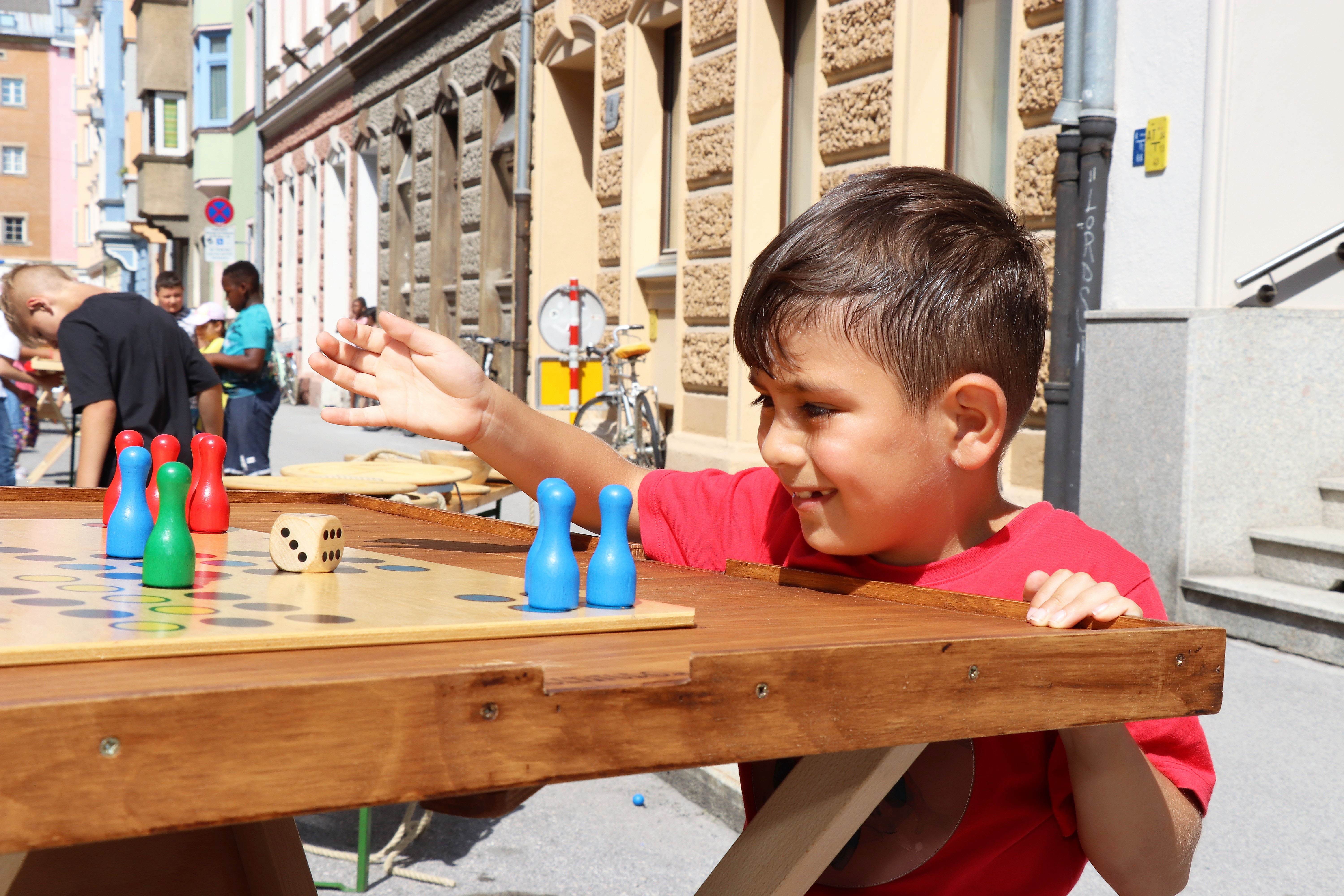 Am 1. Juli begrüßten die SchülerInnen der Volksschule Franz-Fischer-Straße Bürgermeister Georg Willi bei ihrem Sommerfest mit Spielen aus alter Zeit. Nicht nur die Kinder, auch der Bürgermeister waren trotz Hitze mit Feuereifer bei der Sache.