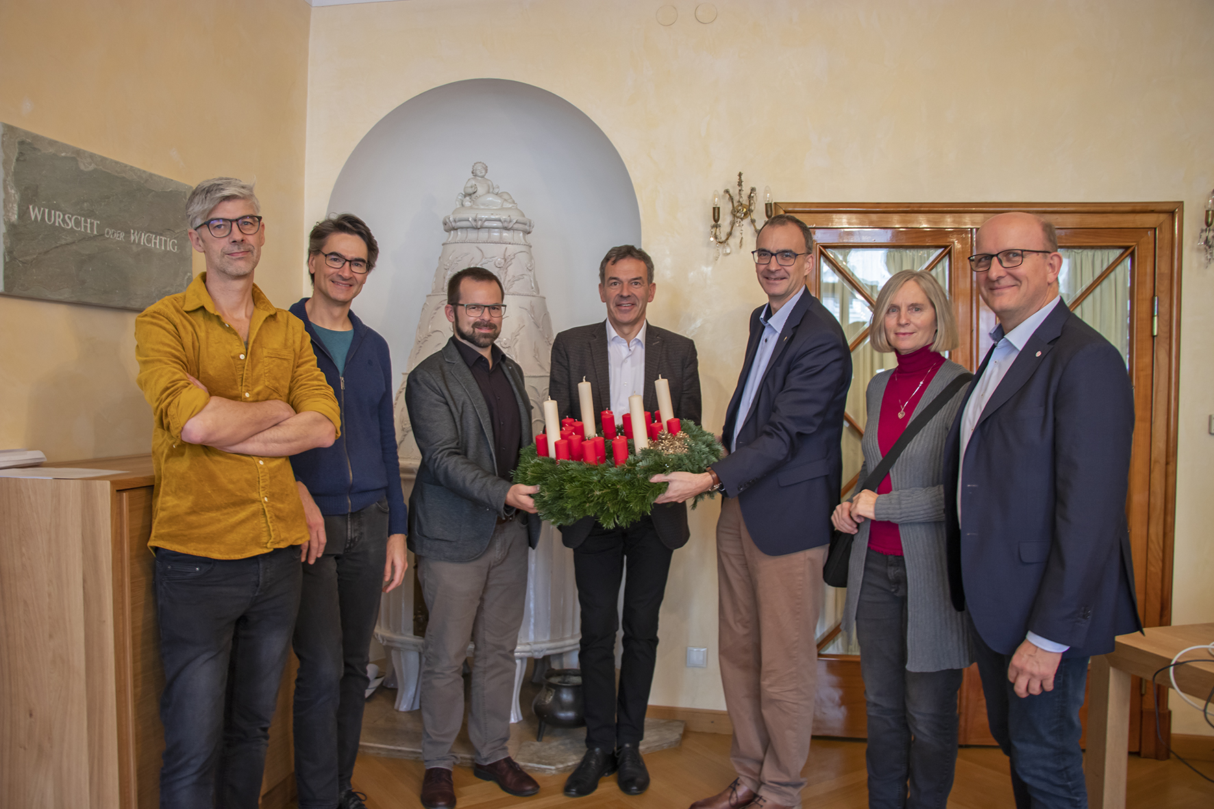 Die diakonischer Organisationen in Tirol überreichten als Dankeschön Bürgermeister Georg Willi einen „Wichern-Adventkranz“. Dabei nützten die Vertreter der Sozialorganisationen die Gelegenheit, ihre Arbeit in kurzen Worten vorzustellen und ihre Anliegen an die Stadt Innsbruck zum Ausdruck zu bringen. Die Diakonie möchte mit dieser kleinen vorweihnachtlichen Geste für die tatkräftige Unterstützung ihrer Arbeit danken. Der Adventkranz ist eng mit den Wurzeln der Diakonie verbunden. Um Kindern aus ärmsten Verhältnissen die Zeit bis Weihnachten zu verkürzen, entzündete der Gründer der Diakonie Johann Hinrich Wichern im "Rauhen Haus" der Diakonie 1839 in Hamburg jeden Tag eine Kerze an einem Wagenrad, das er mit 19 kleinen roten und vier großen Kerzen geschmückt hatte. Aus dieser Idee entstand der uns heute bekannte Adventkranz. (v.l.) Michael Kerber (Diakonie Flüchtlingsdienst, Leitung und Rechtsberatung), Werner Geißelbrecht (Pfarrer Christuskirche Saggen), Stephan Mader (Diakoniewerk Soziale Dienstleistung GmbH, Bereichsleitung Tirol), Bürgermeister Georg Willi, Olivier Dantine (Superintendent der evangelischen Kirche für die Diözese Salzburg-Tirol), Renate Gabriel (Diakonischer Verein Tirol, StudentInnen-Wohnheim Saggen) und Franz Bittersam (Geschäftsführer Johanniter Tirol).