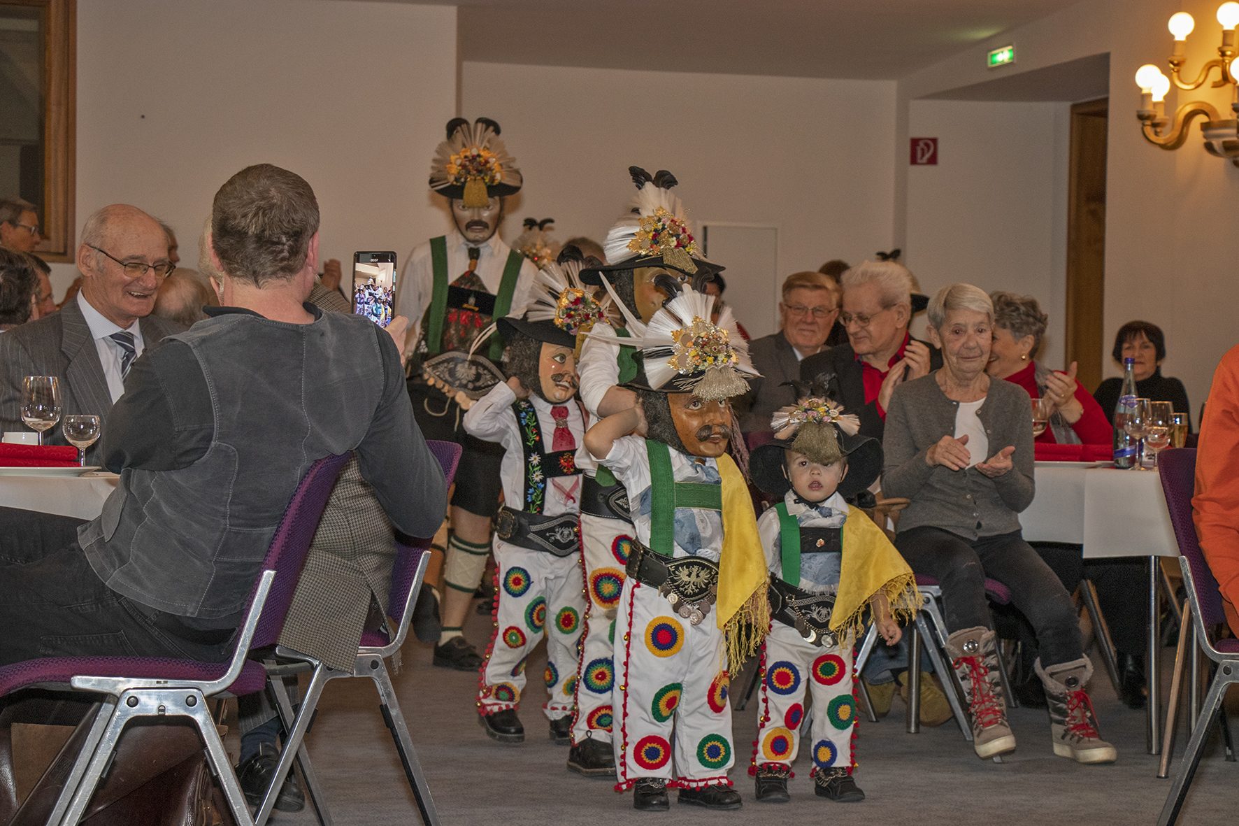 Hochzeitsjubiläen gehören gefeiert, besonders wenn zwei Menschen seit 50, 60 oder mehr Jahren Seite an Seite durchs Leben gehen. Aus diesem Grund lädt die Stadt traditionell Innsbrucker Ehepaare zu einer Hochzeitsjubiläumsfeier in die Ursulinensäle ein. Bürgermeister Georg Willi freut sich über die vielen fröhlichen Gesichter im Saal. „Das Leben eine so lange Zeit mit einem Partner zu verbringen ist einerseits schön, andererseits aber auch eine Aufgabe und Herausforderung. Ich gratuliere Ihnen herzlich zu ihren langen Ehen und möchte Ihnen in diesem Zuge meine Hochachtung aussprechen.“ Gleich zu Beginn der Ehrung hatten die Höttinger Jungmuller ihren großen Auftritt. Sie eroberten die Herzen der JubilarInnen auf Anhieb, und zeigten, dass das alte Faschingsbrauchtum in Hötting in aller Munde ist.