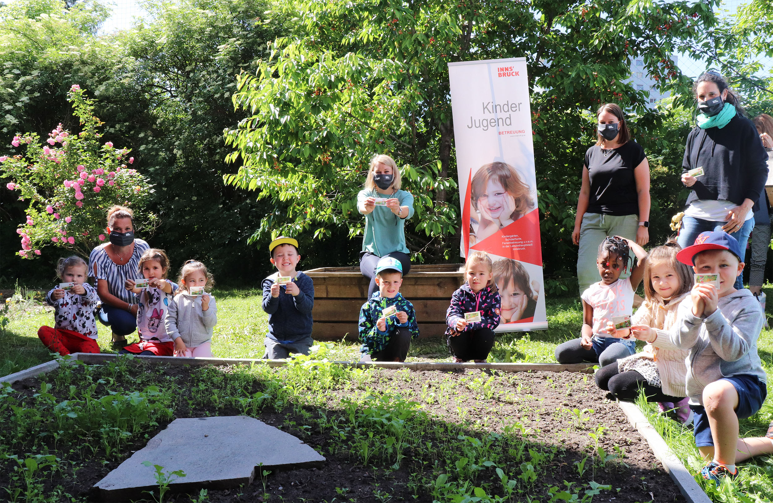 „Innsbruck blüht auf“ – getreu diesem Motto haben in diesen Tagen alle 2.000 Innsbrucker Kindergarten-Kinder Blumensamen als Geschenk erhalten. Die Samen konnten entweder mit nach Hause genommen oder in eines der Blumenbeete im Kindergarten eingepflanzt werden. Bildungsstadträtin Elisabeth Mayr zeigte sich bei einem Besuch im Kindergarten Walderkammweg Neuarzl/Olympisches Dorf begeistert von der Aktion. „Die Kinder lernen nicht nur etwas, es macht ihnen auch Riesenspaß.“ Am Foto mit den Kindern (von links nach rechts): Gruppen-Assistentin Beatrix Pech, Stadträtin Elisabeth Mayr, Kindergarten-Leiterin Nadine Rief und Kindergarten-Pädagogin Sarah Lindig.