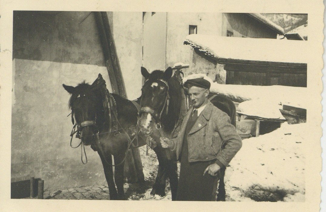 Ein Mann mit zwei Pferden steht vor dem Haus Dorfgasse 9 in Hötting, zwischen 1920 und 1930.