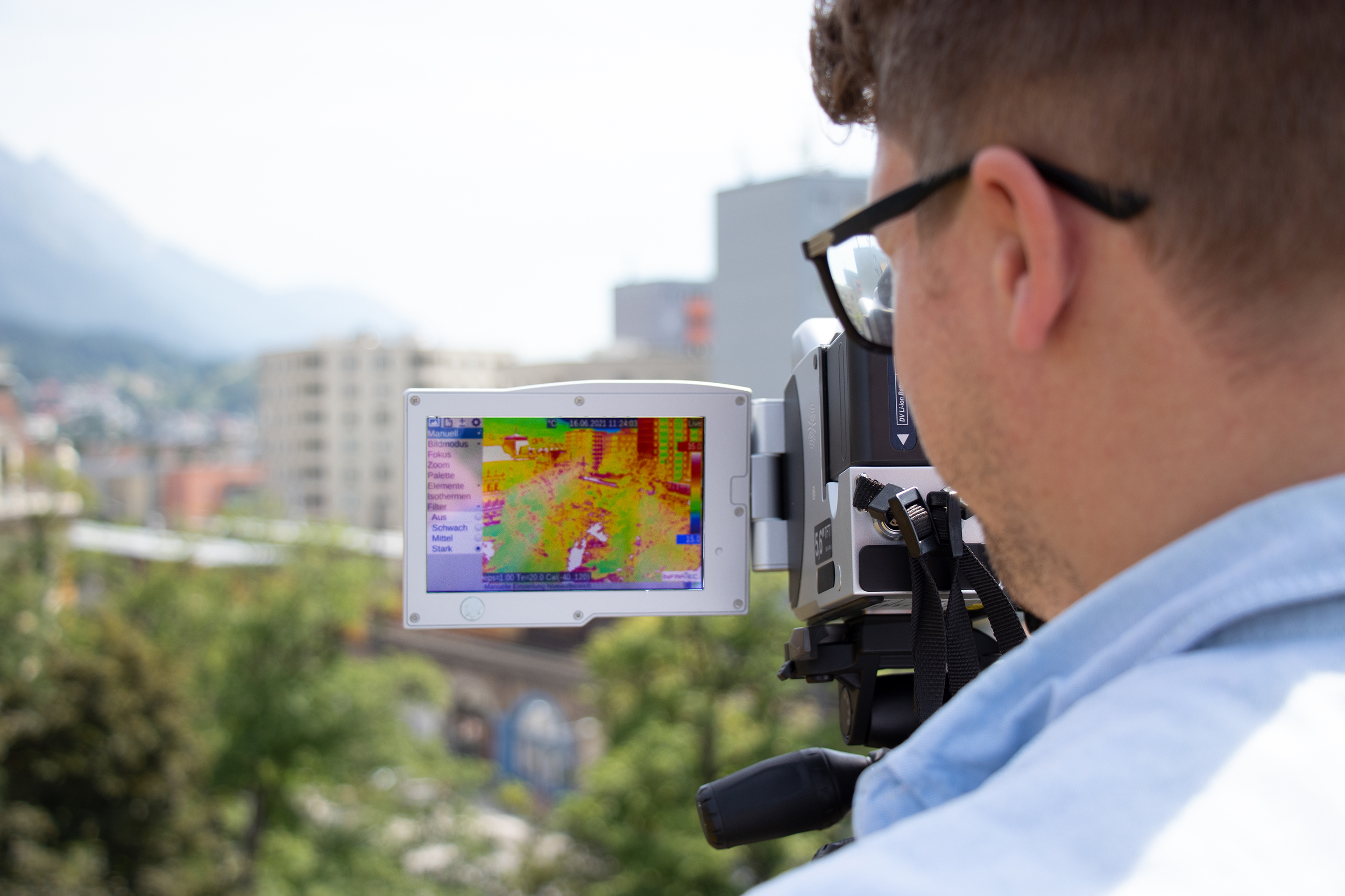 Vom Dach der Messehalle misst Yannick Back mit der Wärmebildkamera die Temperaturen im Park. Rot, also heiß, sind die versiegelten Flächen.
