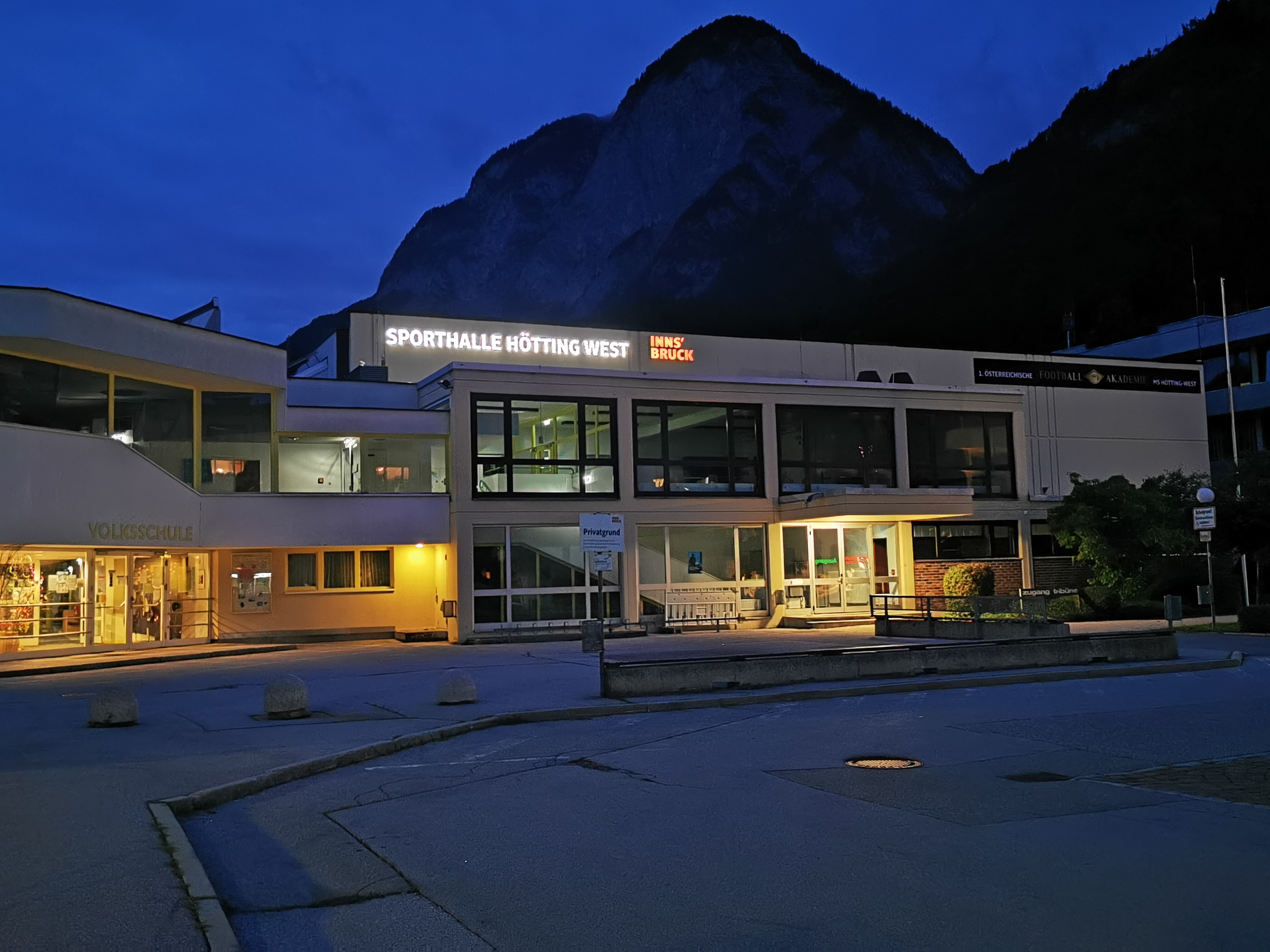 Der neue Schriftzug leuchtet an der Sporthalle Hötting-West ist besonders in den Abendstunden gut erkennbar.