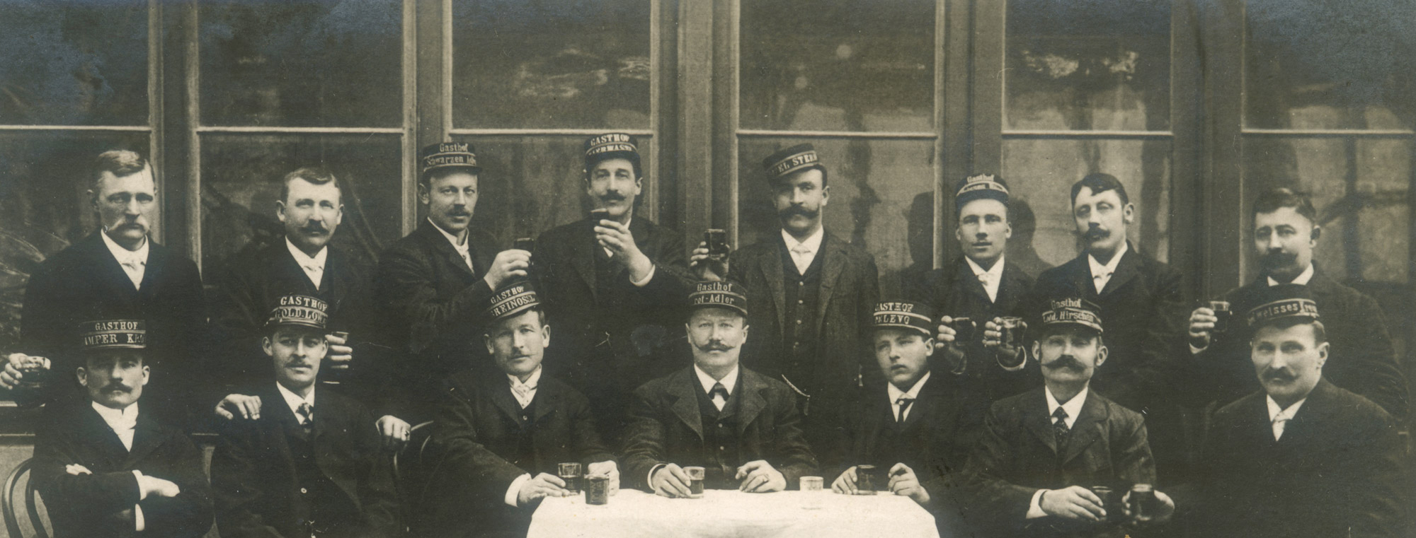 Selbst wenn sie sich privat, in geselligem Rahmen trafen, trugen die Mitglieder des Vereins der Innsbrucker Kommissionäre ihre Uniformen, ihre Kopfbedeckungen, versehen mit dem Namen jenes Hotels oder Gasthauses, für das sie arbeiteten. (vor 1911)