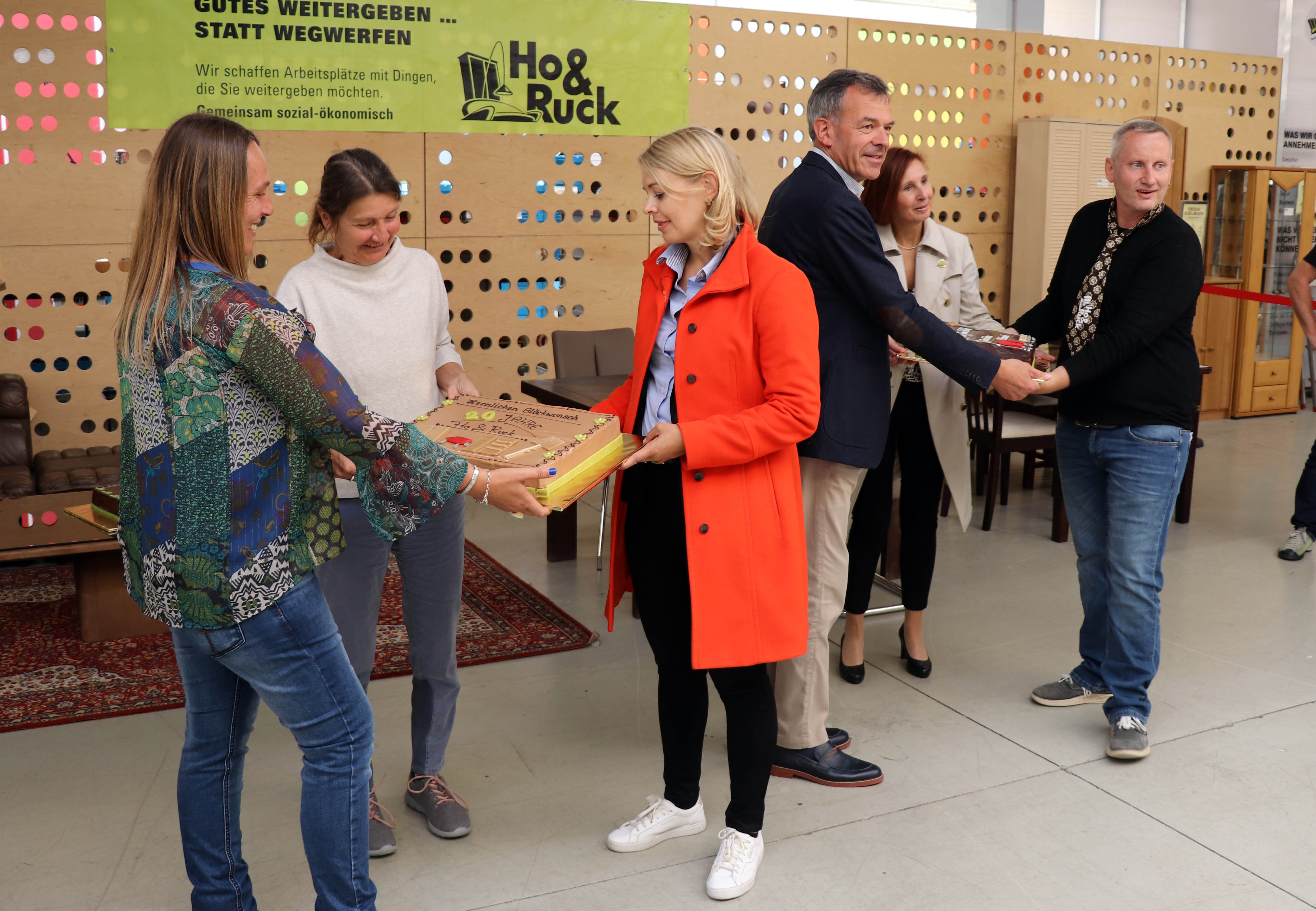 Seit genau 20 Jahren ist das gemeinnützige Unternehmen Ho&Ruck in der ehemaligen Lodenfabrik an der Hallerstraße beheimatet und hat sich zu einer Institution in Innsbruck entwickelt. Bürgermeister Georg Willi (3. v. r.) gratulierte gemeinsam mit den beiden Stadträtinnen Elisabeth Mayr (3. v. l.) und Uschi Schwarzl (2. v. l.) sowie Landesrätin Gabriele Fischer (2. v. r.) anlässlich des runden Jubiläums. Als kleine Aufmerksamkeit überreichten sie zwei prachtvolle Torten an die beiden GeschäftsführerInnen Martina Wolf-Kuntner und Thomas Holzer.