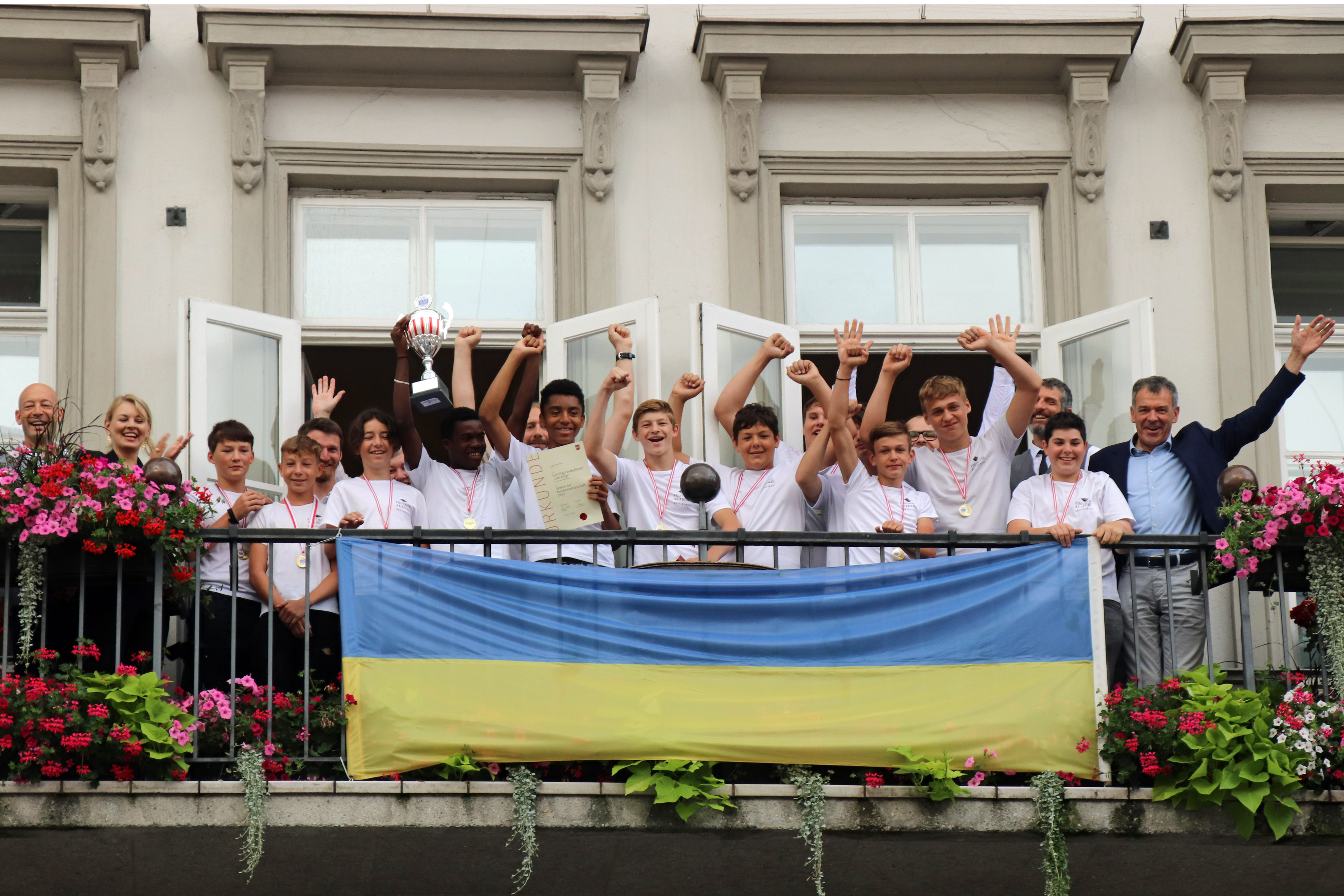 Gemeinsam mit Bürgermeister Georg Willi (r.), Stadträtin Elisabeth Mayr (2.v.l.) und Daniel Dieplinger, Leiter der Football Akademie (l.), strahlten die Bundesmeister der Flag Football Schülerliga vom Rathausbalkon.
