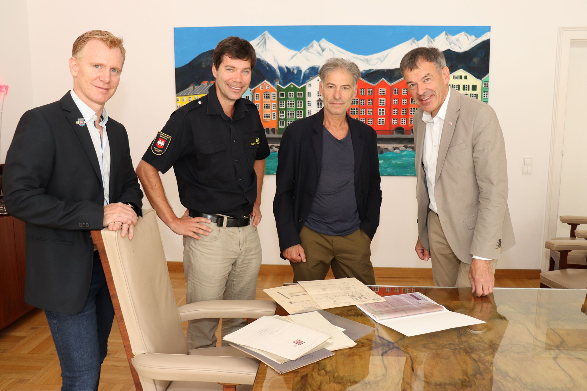 Bürgermeister Georg Willi, Christian Kugler (Amtsvorstand, Bau- und Feuerpolizei; 1.v.l.), Manfred Hirsch (Referatsleiter GWR; 2.v.l.) und Firmenchef Peter Walde bei der Übergabe der alten Pläne.