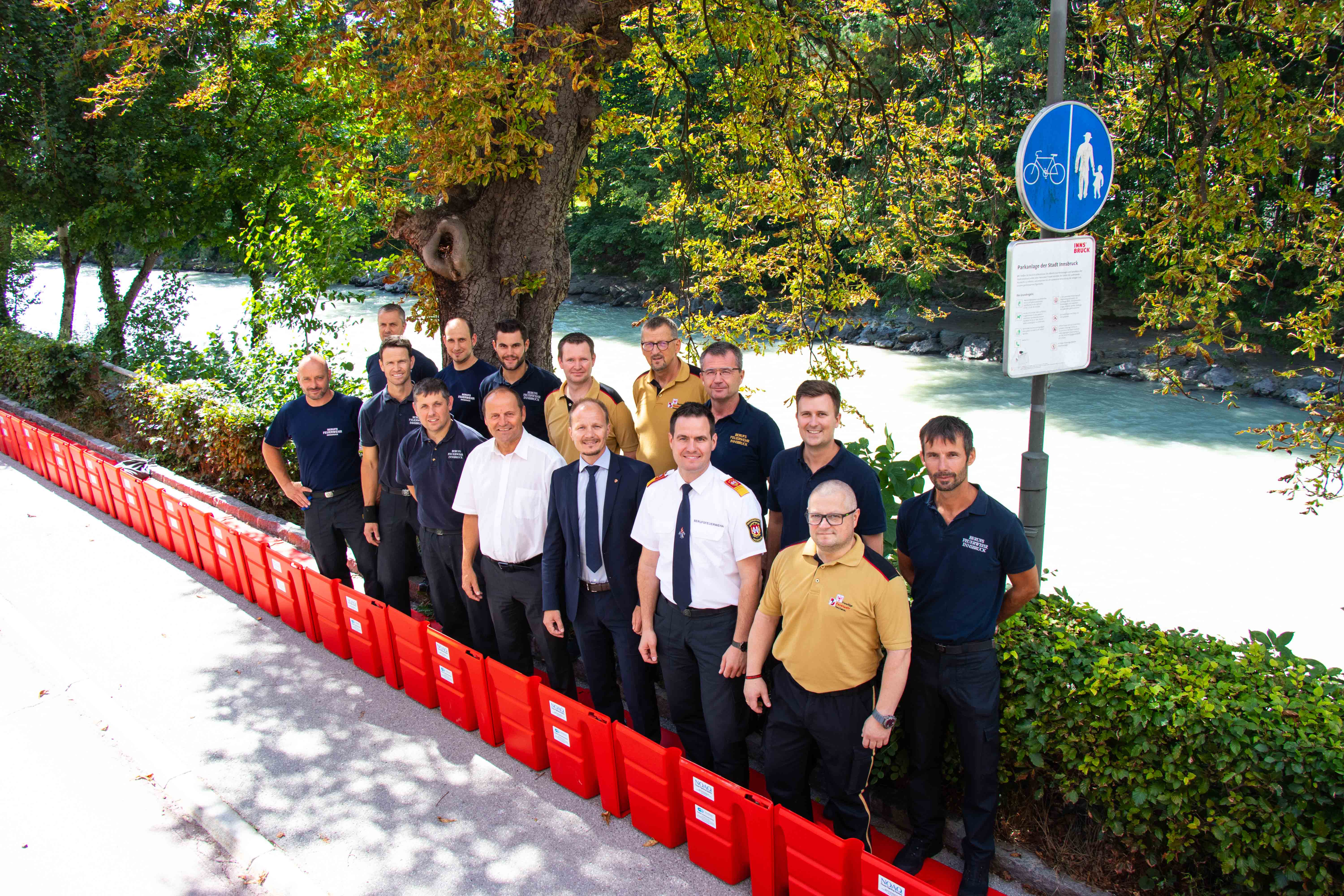 Beim Lokalaugenschein der neuen Hochwasserschutzelemente: LH-Stv. Josef Geisler (vorne, 4.v.l), Vizebürgermeister Johannes Anzengruber (vorne, 3.v.r) und Branddirektor Helmut Hager (vorne, 2.v.r) mit Männern der Freiwilligen- und Berufsfeuerwehr Innsbruck.