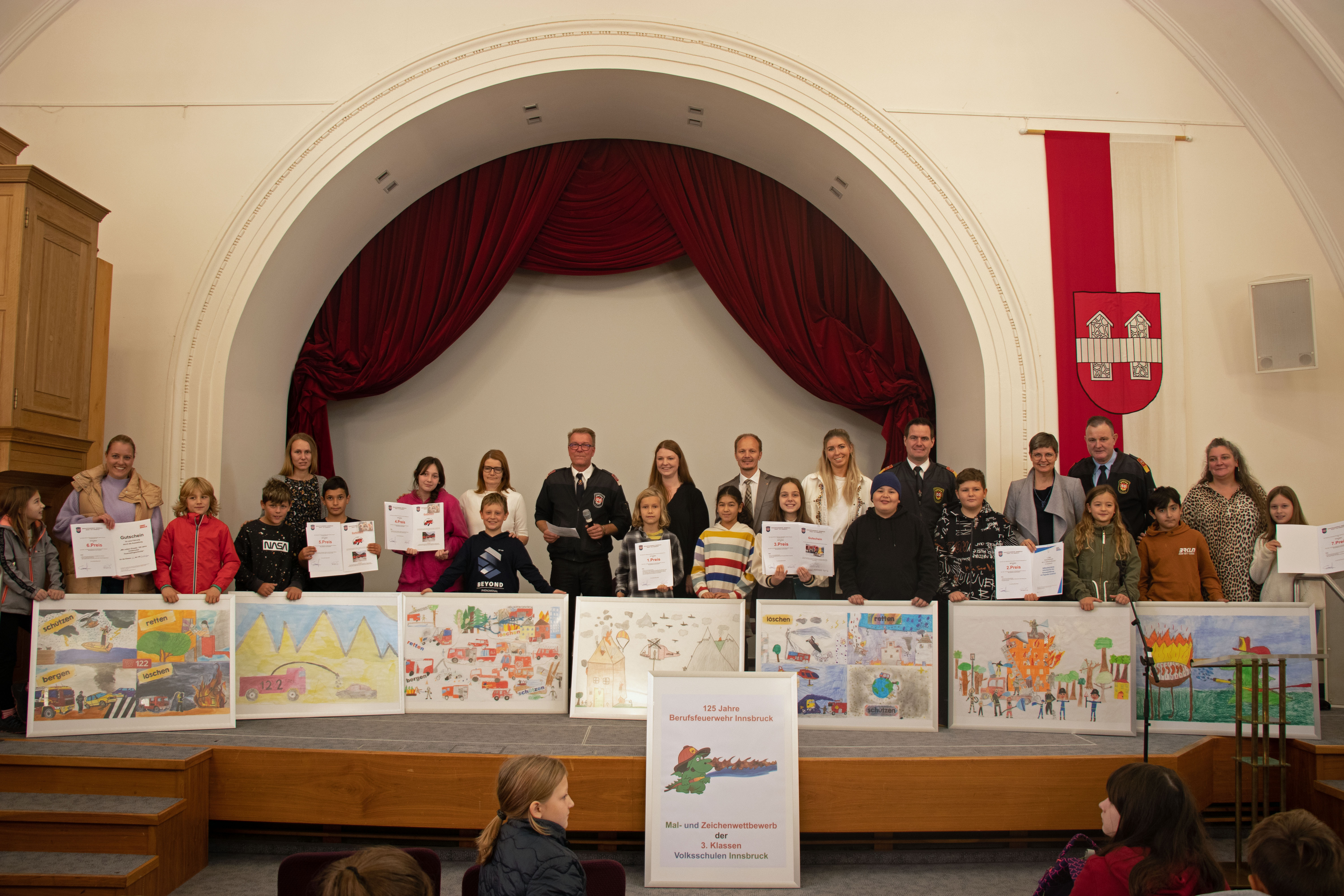 Die Schülerinnen und Schüler aus sieben Klassen der VS Amras, Arzl, Dreiheiligen, Hötting West, Mühlau und Reichenau freuen sich gemeinsam mit Vizebürgermeister Johannes Anzengruber sowie den organisierenden Feuerwehrleuten über die Kunstwerke, eine gelungene Preisverleihung und tolle Preise für alle Teilnehmenden.