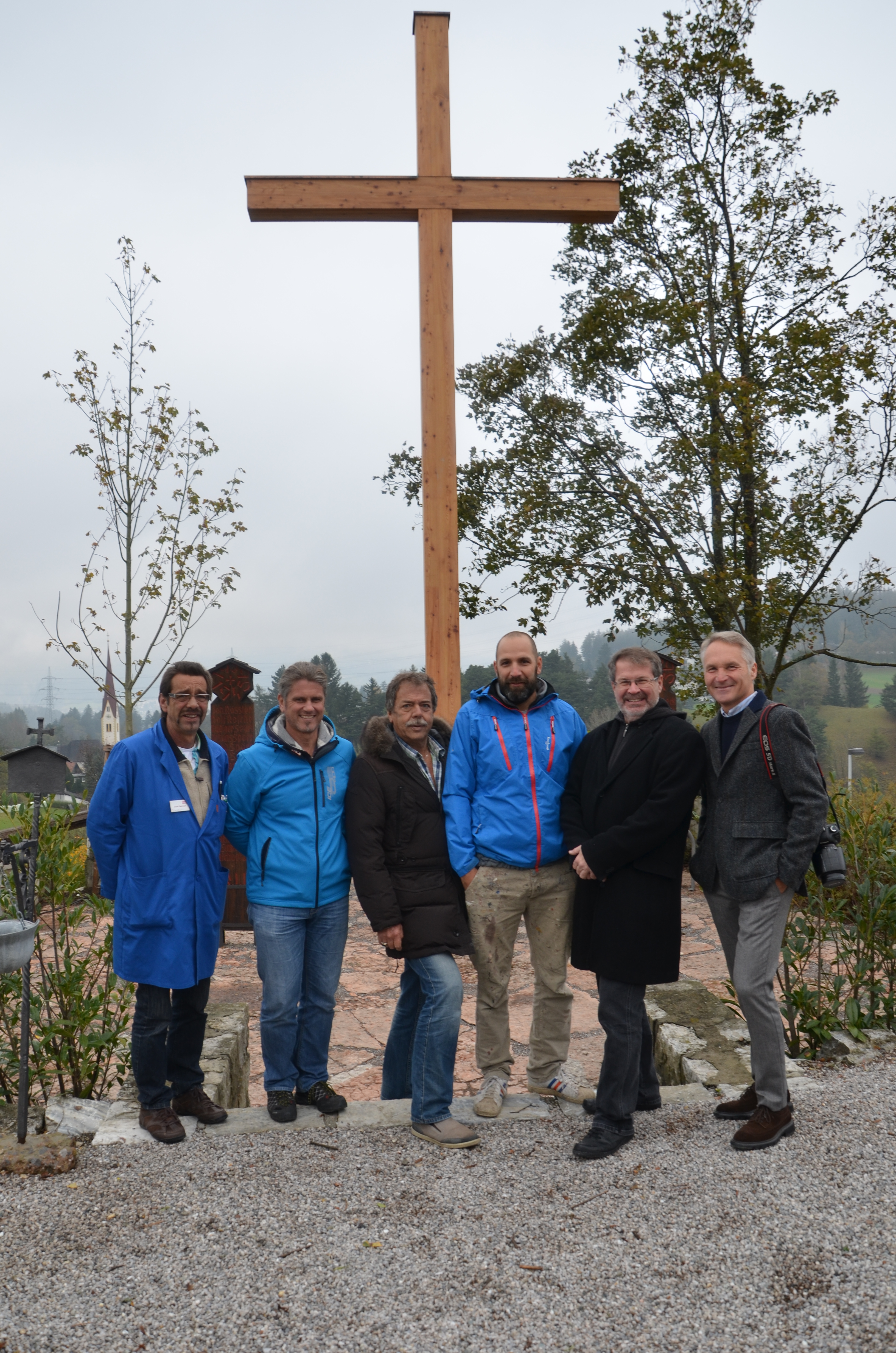 Vor dem neu errichteten Hochkreuz und den restaurierten Holzstelen: Mitarbeiter des städtischen Gartenamtes Josef Reinisch und Stefan Engele, Stadtrat Gerhard Fritz, Künstler und Restaurator Martin Zulehner, Referatsleiter städtische Friedhöfe Alexander Legniti und Mitglied des Stadtteilberatungsausschusses Klaus Defner