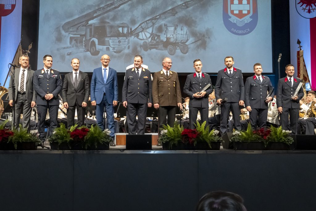 Bürgermeister Georg Willi, Branddirektor Helmut Hager, Vizebürgermeister Johannes Anzengruber, Landeshauptmann Anton Mattle, BD-Stv. Johann Zimmermann und ÖBVF-Vizepräsident und Altlandesfeuerwehrkommandant Peter Hölzl freuen sich mit den versammelten Feuerwehrleuten über einen gelungenen Jubiläumsabend.