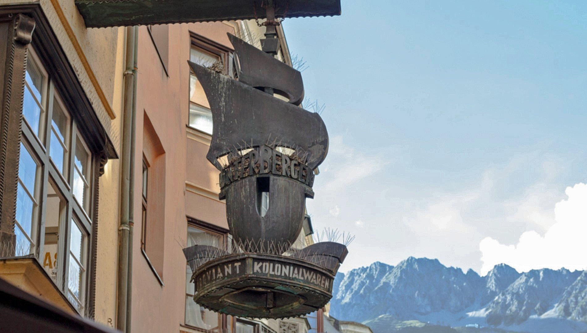 Nasenschild der Firma "Unterberger & Comp." (Herzog-Friedrich-Straße 26, Innsbruck) mit der Aufschrift "Kolonialwaren".