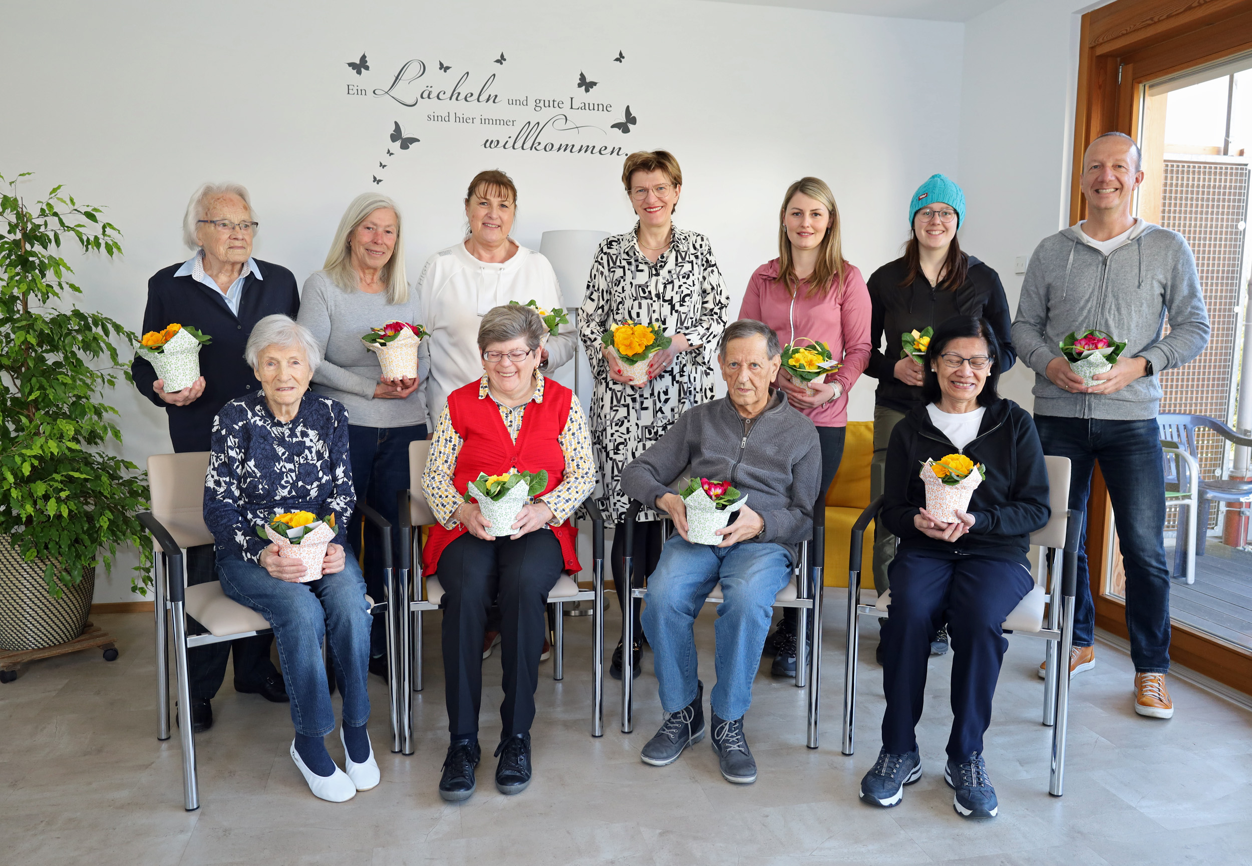 Stadträtin Christine Oppitz-Plörer (4.v.l., stehend) überreichte gemeinsam mit Christine Kurz (Leitung ISD-SeniorInnenwohnen, 3.v.l., stehend), Stefan Hetzenauer (ISD-Wohnanlage Pradl, r., stehend) sowie den Stadtgärtnerinnen Ramona Prinoth (3.v.r., stehend) und Stefanie Huetz (2.v.r., stehend) blumige Valentinsgrüße an BewohnerInnen der SeniorInnenwohnanlage Pradl.