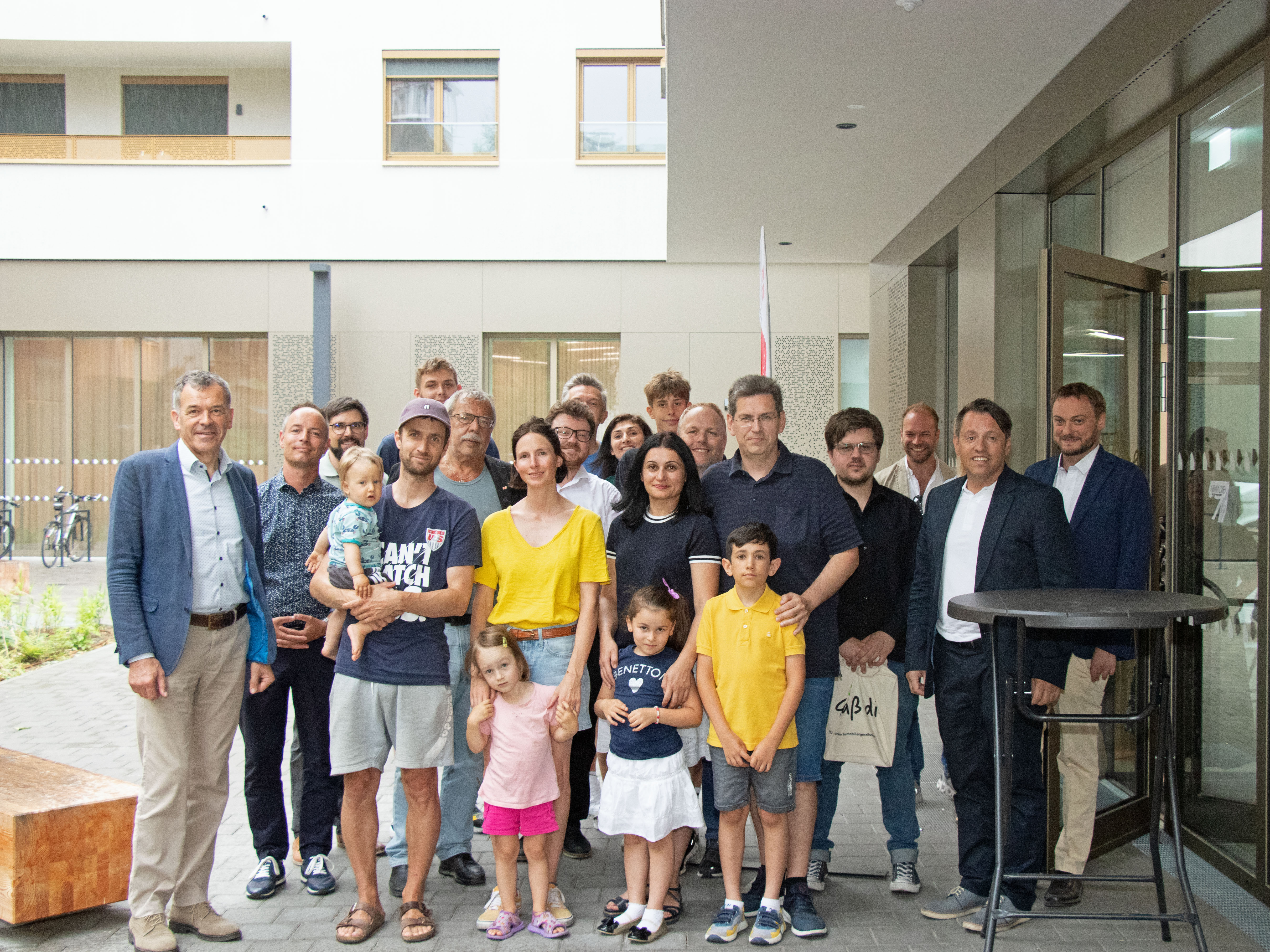 Bürgermeister Georg Willi (l.), Vizebürgermeister Markus Lassenberger (2.v.l.), die Gemeinderäte Gerhard Fritz (2. R., 2.v.l.), Benjamin Plach (2.R, 3.v.l.), Lucas Krackl (2.R., 4.v.l.) und IIG-Geschäftsführer Franz Danler (2.v.r) freuen sich gemeinsam mit den MieterInnen sowie Vertretern der Baufirma und der Hausverwaltung über zwölf neue städtische Mietwohnungen in Pradl.