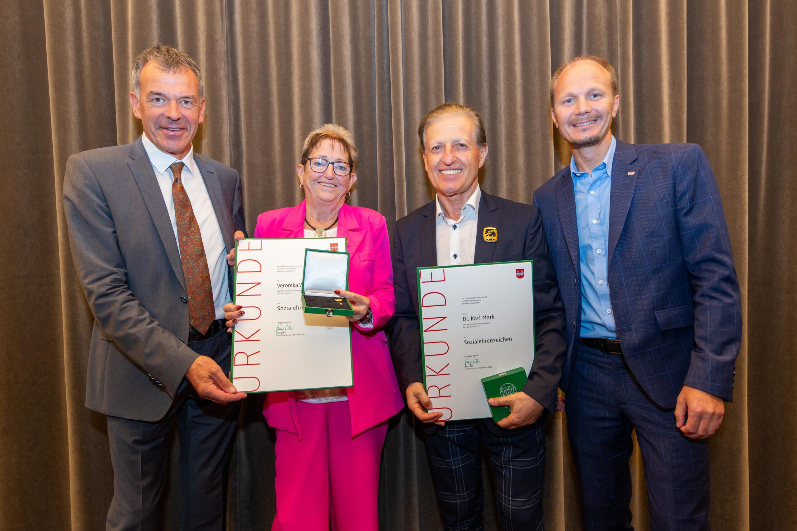 Bürgermeister Georg Willi und Vizebürgermeister Johannes Anzengruber (r.) überreichten Veronika Wallnöfer und Karl Mark das Sozialehrenzeichen der Stadt Innsbruck.