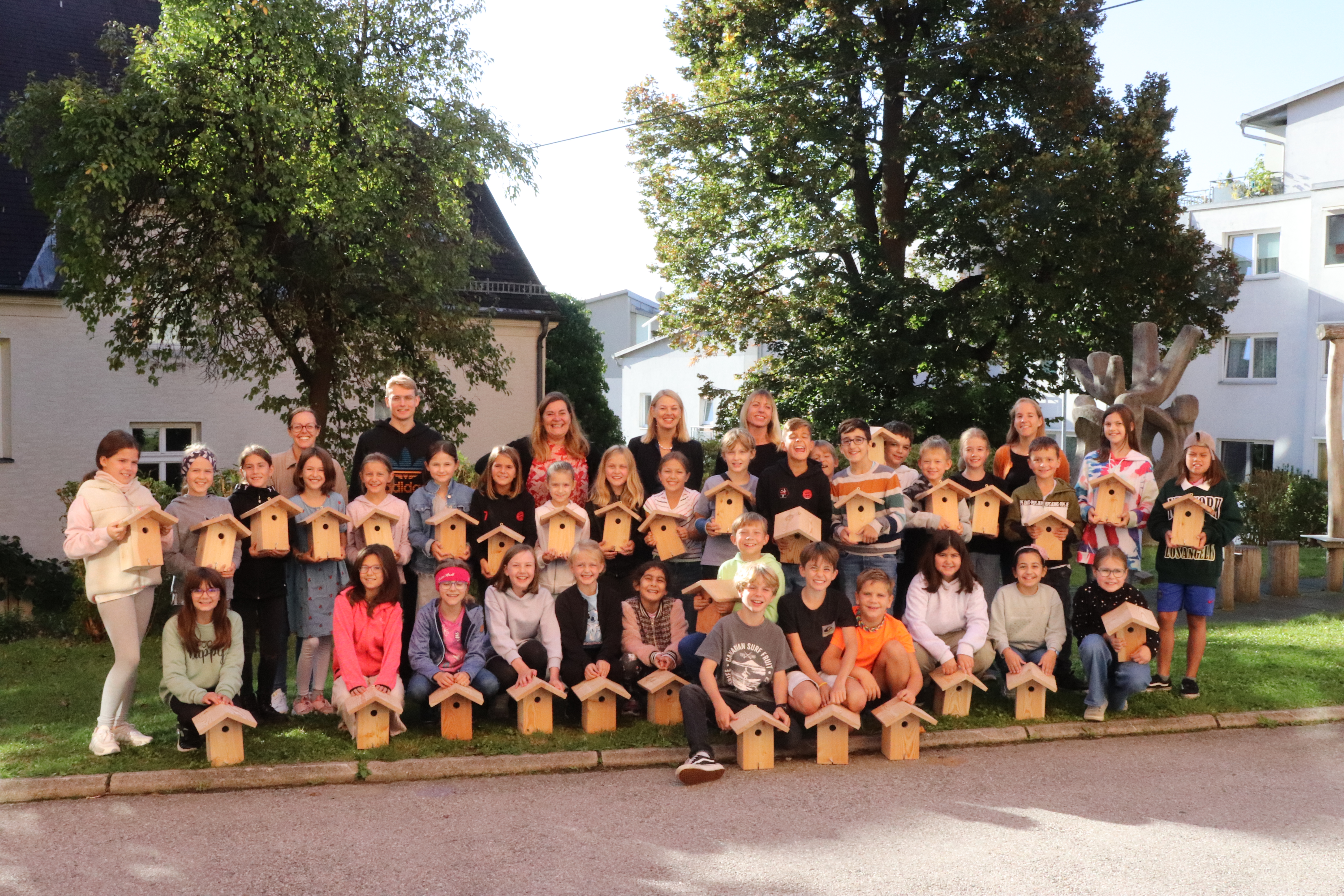 Ein ökologischer Beitrag: Die Kinder der Volksschule Hötting freuten sich über die Vogelnistkästen, gemeinsam mit Stadträtin Elisabeth Mayr (hintere Reihe, 2.v.r.), Projektleiterin Isabella Prossliner (hintere Reihe, 1.v.r.) und Direktorin Dagmar Klingler (hintere Reihe, 3.v.l.).