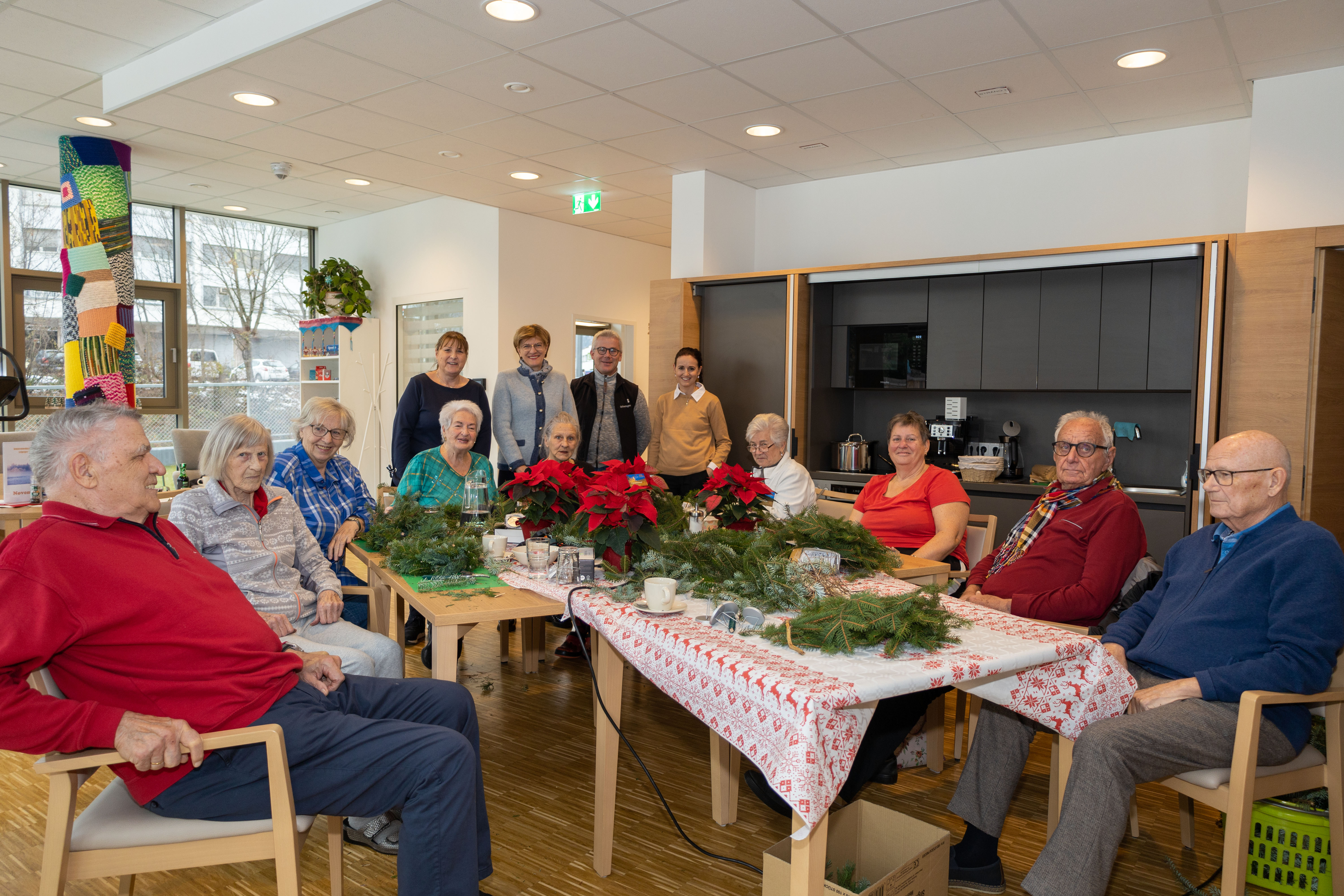 Stadträtin Christine Oppitz-Plörer (hinten, 2. v. l.) überreichte den SeniorInnen in der Wohnanlage am Leipziger Platz einen Weihnachtsstern, gemeinsam mit ISD-Bereichsleiterin Christine Kurz (hinten, links) und Carina Pardeller (Ansprechpartnerin Wohnanlage am Leipziger Platz) sowie Michael Gapp von der Stadtgärtnerei.