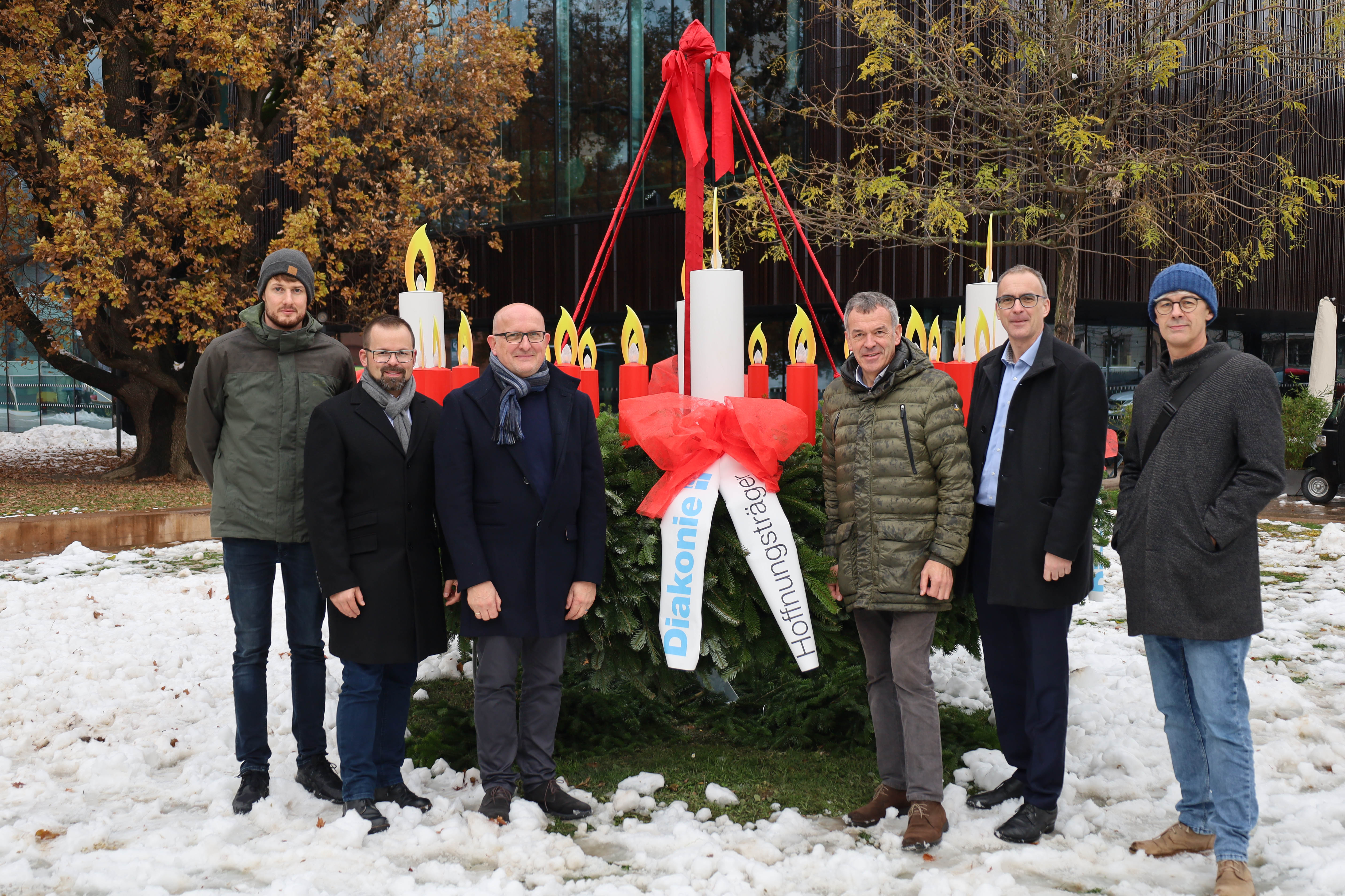 Innsbrucks Bürgermeister Georg Willi (3.v.r.) freut sich mit Stefan Gartlacher (Diakonischer Verein Tirol, StudentInnenwohnheim Saggen), Stephan Mader (Bereichsleitung, Prokurist Diakoniewerk Tirol), Franz Bittersam (Geschäftsführer Johanniter Tirol), Olivier Dantine (Superintendent) und Michael Kerber (Flüchtlingshilfe) über die Adventkränze vor dem Haus der Musik und im Stadtsenat-Sitzungszimmer im Innsbrucker Rathaus. Die Adventkränze sind Geschenke des Diakoniewerks und nach dem Vorbild des originalen Adventkranzes des evangelischen Theologen Johann Hinrich Wichern (1808 - 1881) gestaltet. Dieser verteilte den Adventkranz erstmals 1839 in Hamburg - mit jeweils einer Kerze für jeden Tag des Advents.