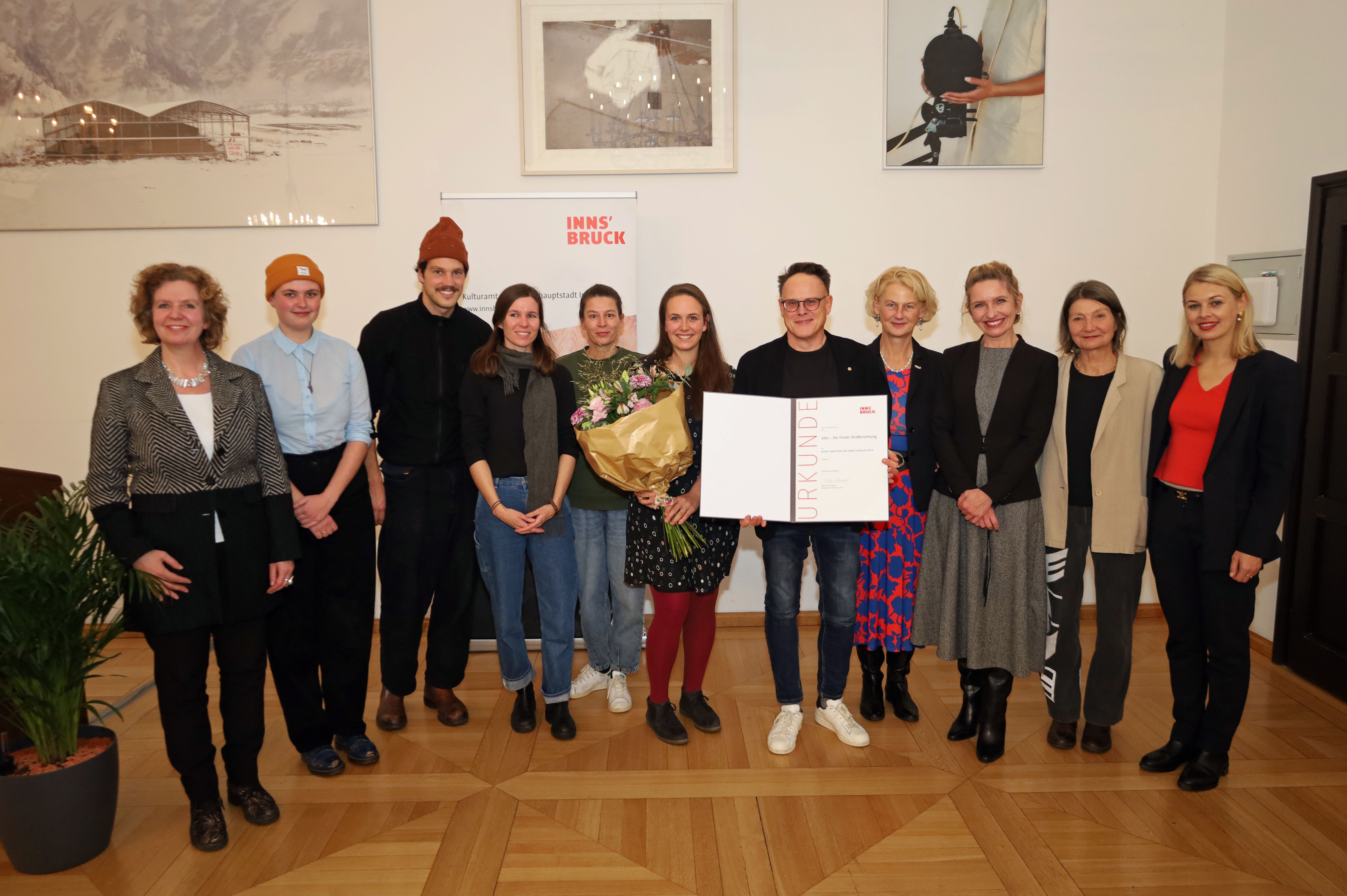 Kulturstadträtin Uschi Schwarzl (2.v.r.) und Stadträtin Elisabeth Mayr (r.) freuen sich mit (v.l.n.r.) Magistratsdirektorin Gabriele Herlitschka, den 20er-MitarbeiterInnen Sophie Westreicher, Caspar Wolf, Theresa Girardi und Birgit Schmoltner, 20er-Chefredakteurin Rebecca Sandbichler, 20er-Mitgründer Uwe Steger, LFU-Rektorin Veronika Sexl und Kulturamtsleiterin Isabelle Brandauer über den diesjährigen Arthur-Haidl-Preis für den 20er.