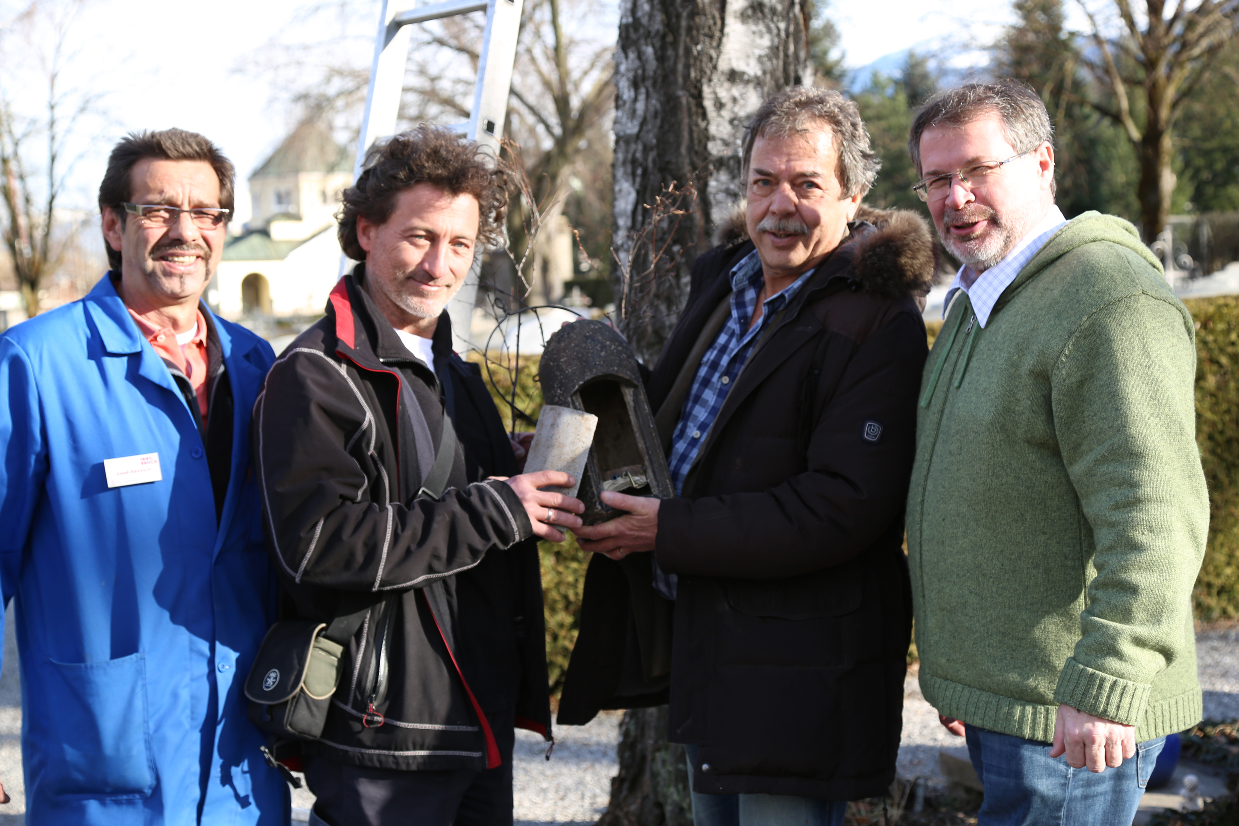 Die Höhlenimitation als Nisthilfe für Fledermäuse wird am Innsbrucker Ostfriedhof angebracht (v.l.): Mitarbeiter der städtischen Grünanlagen Josef Reinisch, Projektleiter Anton Vorauer, Stadtrat Gerhard Fritz und Referatsleiter für städtische Friedhöfe Alexander Legniti.