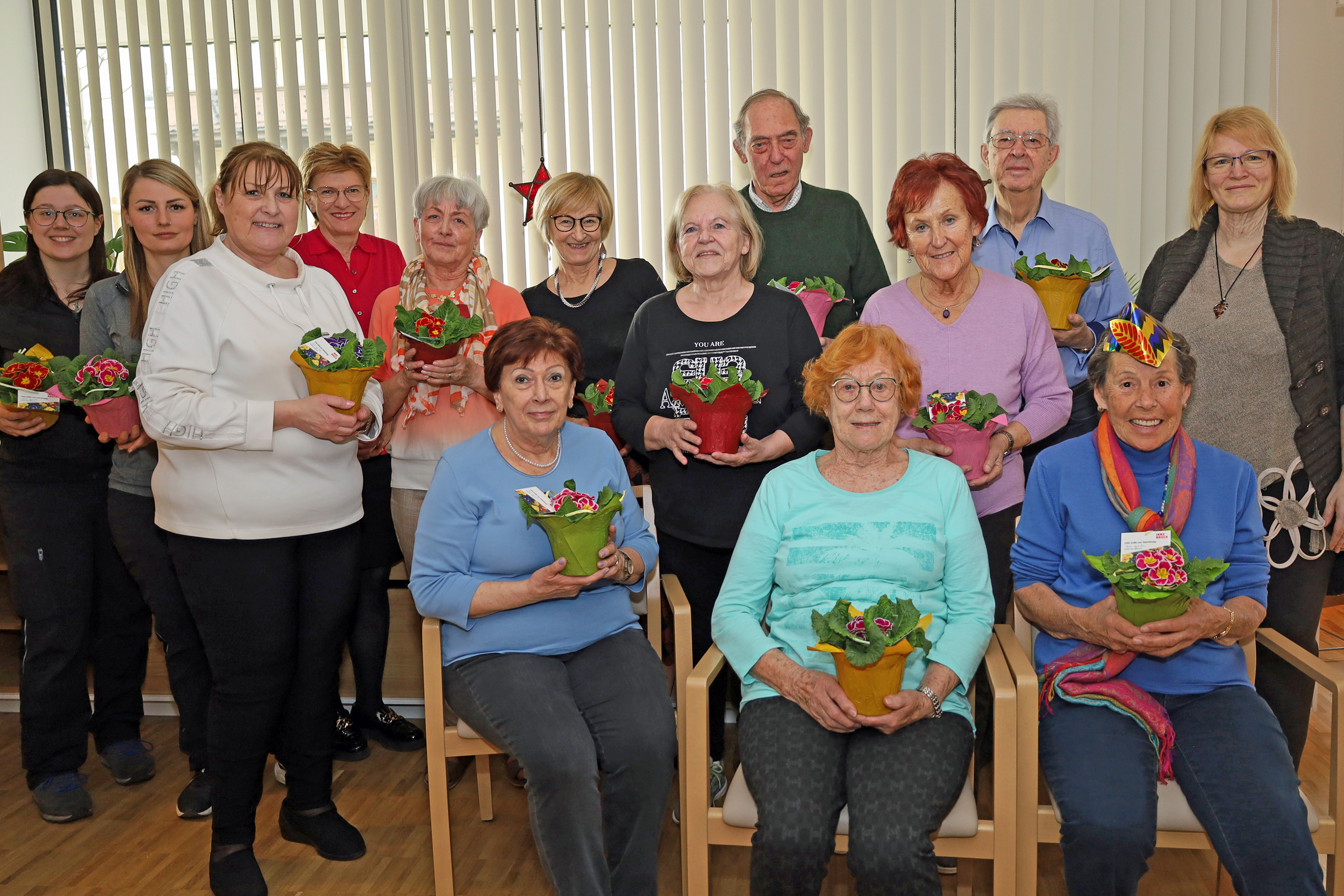 Stadträtin Christine Oppitz-Plörer (4.v.l., stehend) überreichte gemeinsam mit Christine Kurz (Leitung ISD-SeniorInnenwohnen, 3.v.l., stehend), Verena Plattner (ISD-Wohnanlage Igls, r., stehend) sowie den Stadtgärtnerinnen Ramona Prinoth (2.v.l., stehend) und Stefanie Huetz (l., stehend) blumige Valentinsgrüße an BewohnerInnen der SeniorInnenwohnanlage Igls.