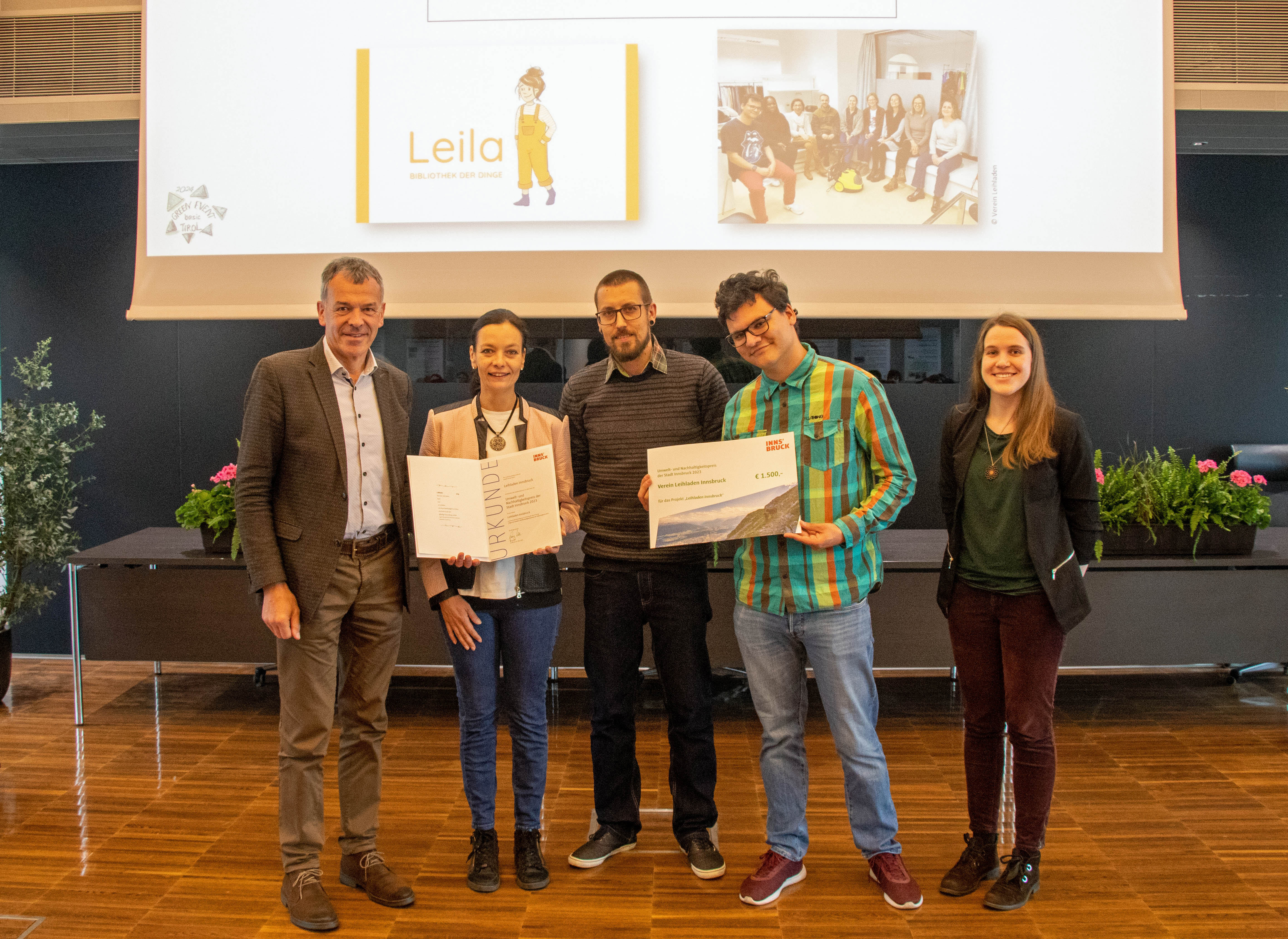 Bürgermeister Georg Willi (l.) und Organisatorin Nadine Winzer (Klimaneutrale Stadt, r.) freuen sich mit den VertreterInnen des Leihladens "Leila" über die Auszeichnung.