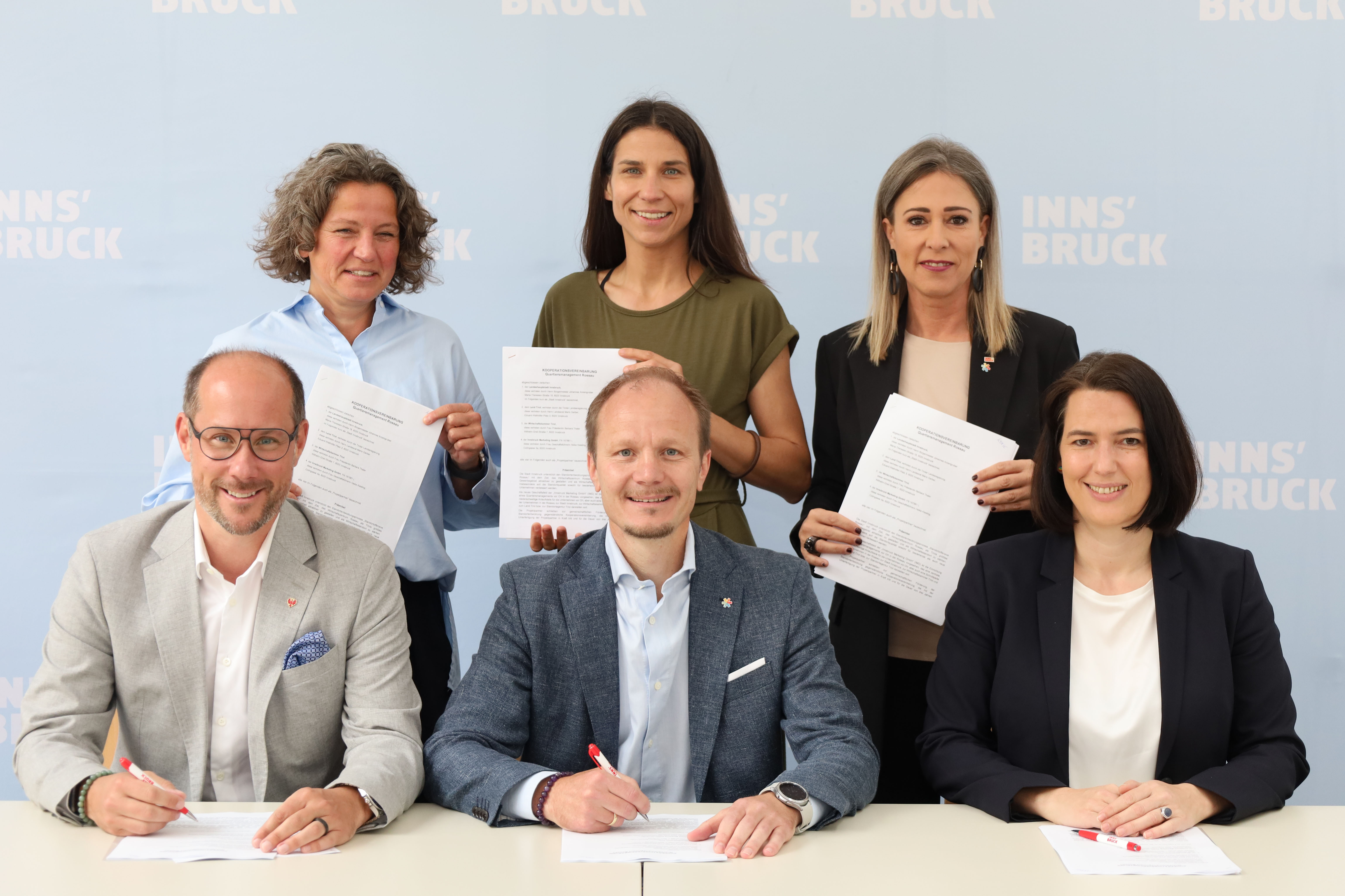 Der Kooperationsvertrag zum Quartiersmanagement Rossau wurde von allen PartnerInnen unterzeichnet: vorne sitzend v.l. Landesrat Mario Gerber, Bürgermeister Johannes Anzengruber, Wirtschaftskammerpräsidentin Barbara Thaler; hinten stehend v.l. Heike Kiesling (Geschäftsführerin Innsbruck Marketing), Stadträtin Janine Bex, Stadträtin Mariella Lutz.