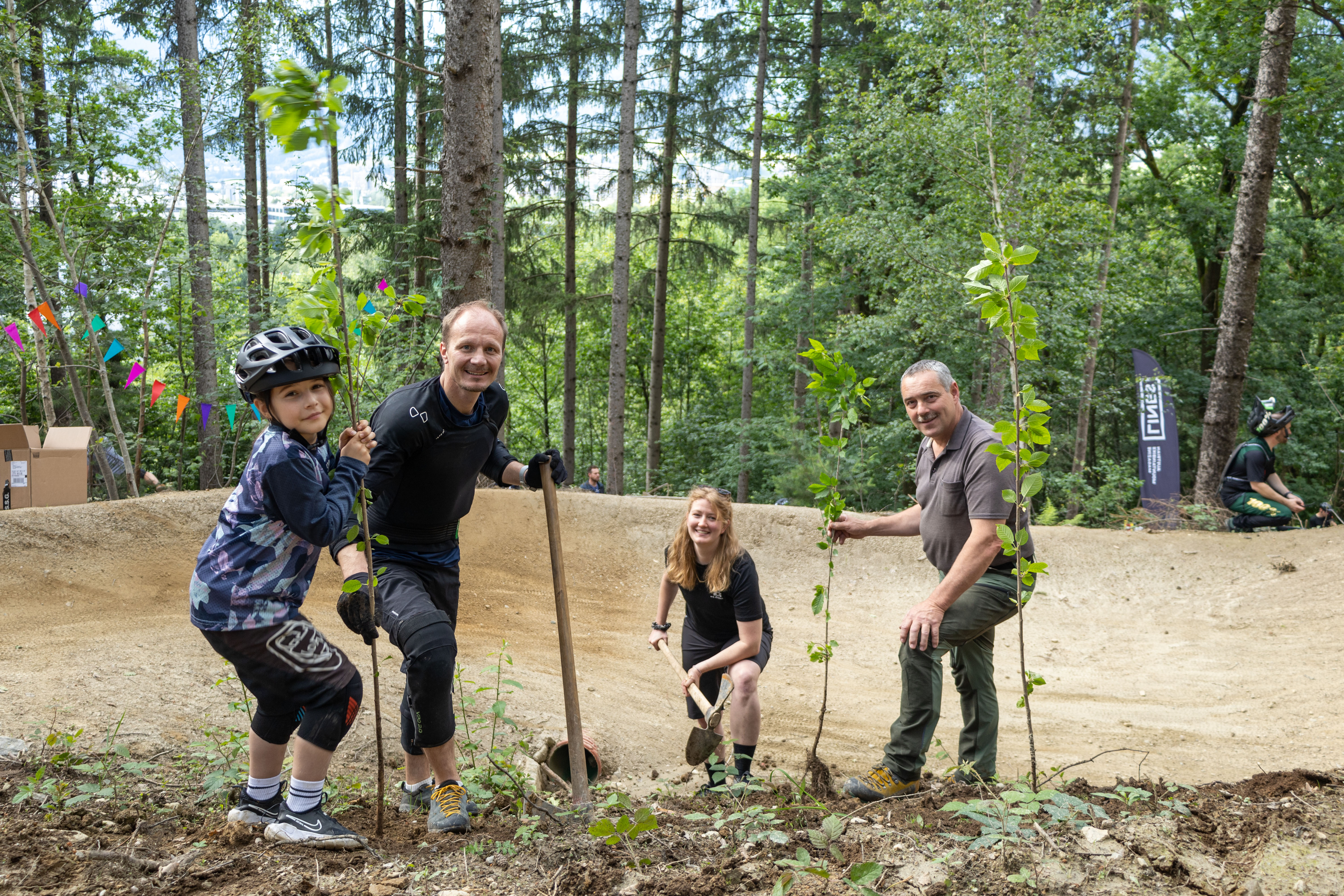 Zum „Einzug“ wurden vor Ort neue Bäume gepflanzt. Weitere Bäume werden beim nächsten Community-Day gepflanzt. Im Bild Bürgermeister Johannes Anzengruber, Verena Böhm-Hennes und Waldaufseher Andreas Hell (r.) mit einer jungen Nachwuchs-Bikerin.