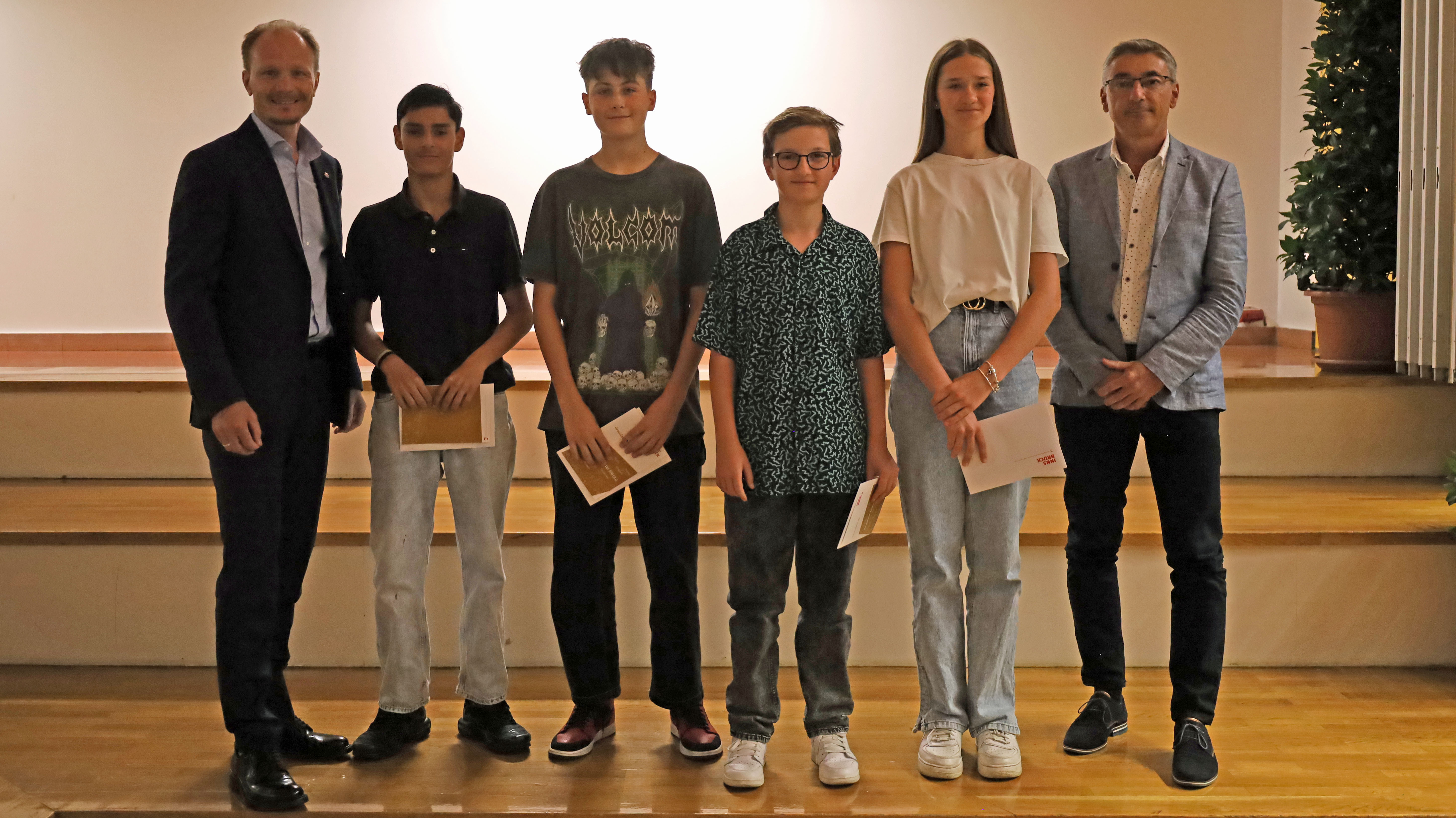 Bürgermeister Johannes Anzengruber (l.) und Schulqualitätsmanager Dietmar Meinschad (r.) mit den ausgezeichneten SchülerInnen der Mittelschule Hötting-West.