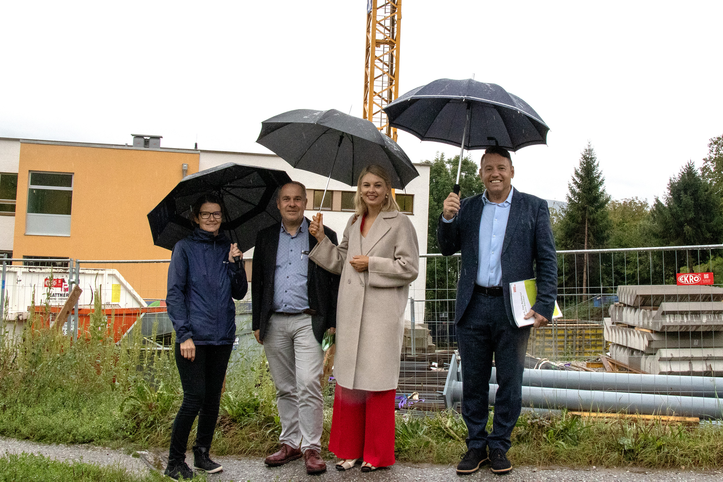 Direktorin Petra Eichler, Projektleiter Walter Aistleitner, Vizebürgermeisterin Elisabeth Mayr und IIG-Geschäftsführer Franz Danler trotzten dem Regenwetter und machten sich ein Bild vom Baufortschritt bei der Volksschule Arzl.