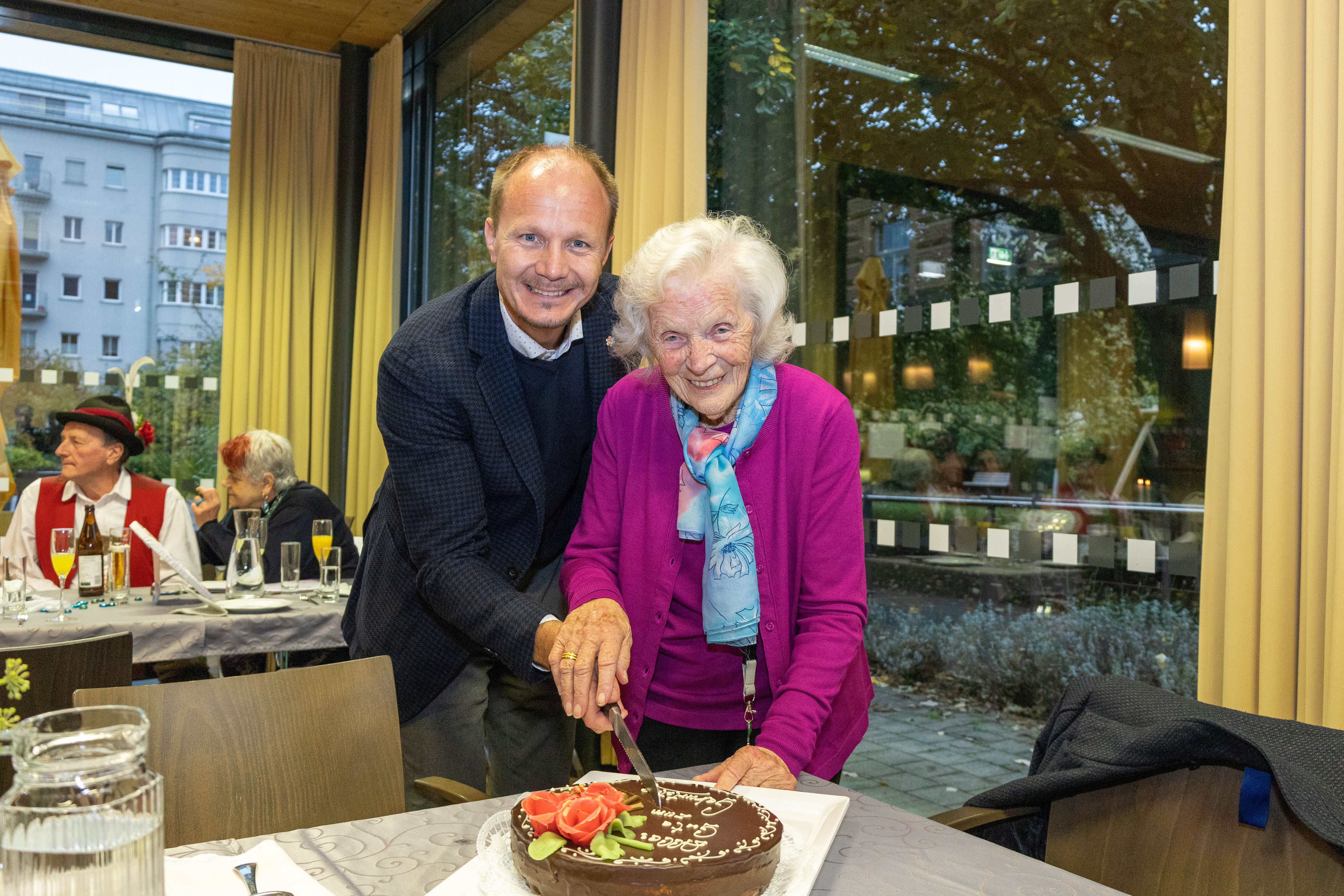 Innsbrucks Stadtoberhaupt Johannes Anzengruber schneidet gemeinsam mit der Jubilarin Josefine Psula die köstliche Geburtstagstorte an.