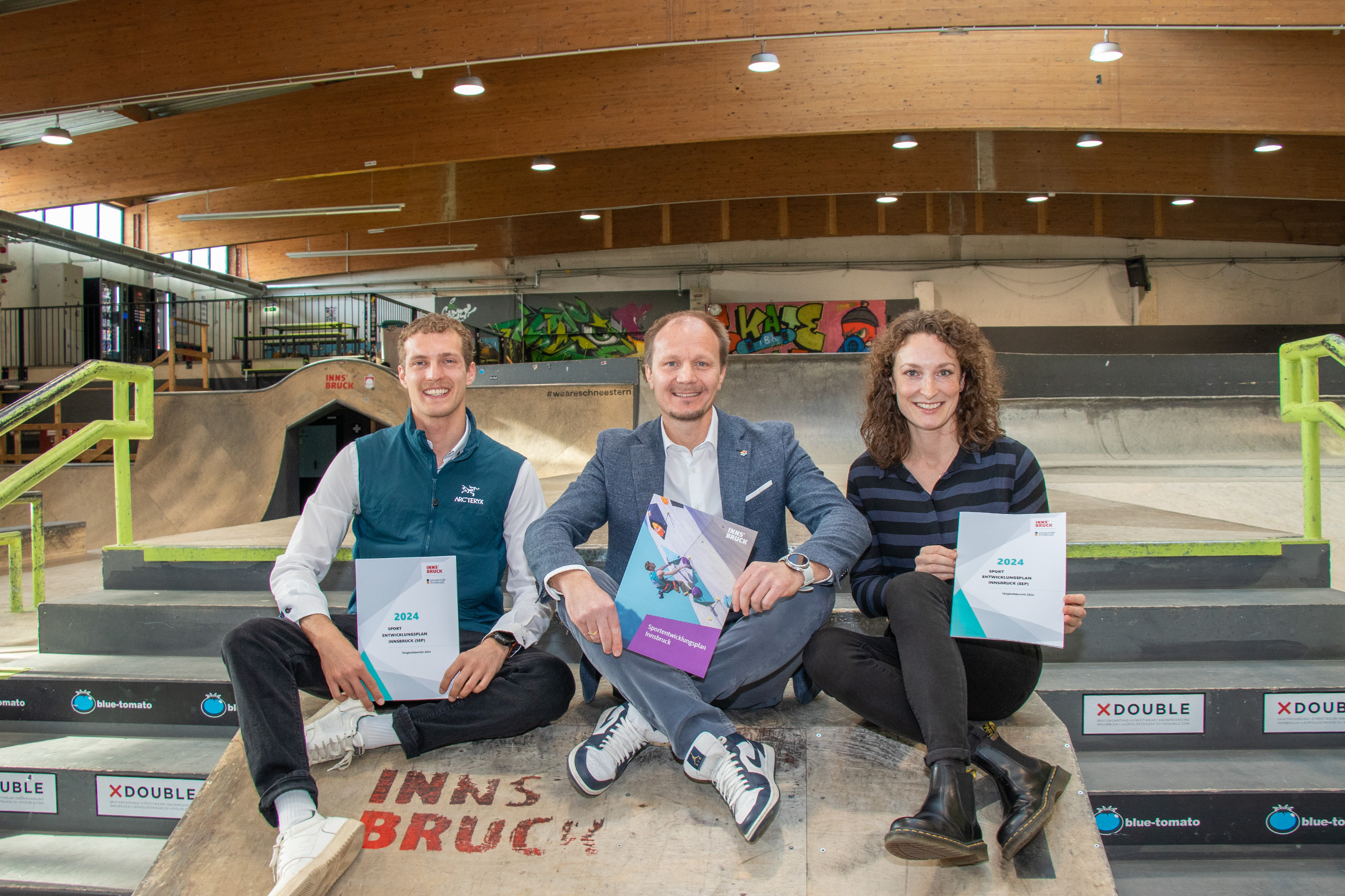 Präsentation des Tätigkeitsberichts 2024: Bürgermeister Johannes Anzengruber, Sabrina Scheiber (r., Institut für Sportwissenschaft) und Projektleiter Tassilo Berghamer (l., Sportamt Stadt Innsbruck) stellten in der Skatehalle Innsbruck die bisherigen Maßnahmen und zukünftigen Schritte des Sportentwicklungsplans vor.