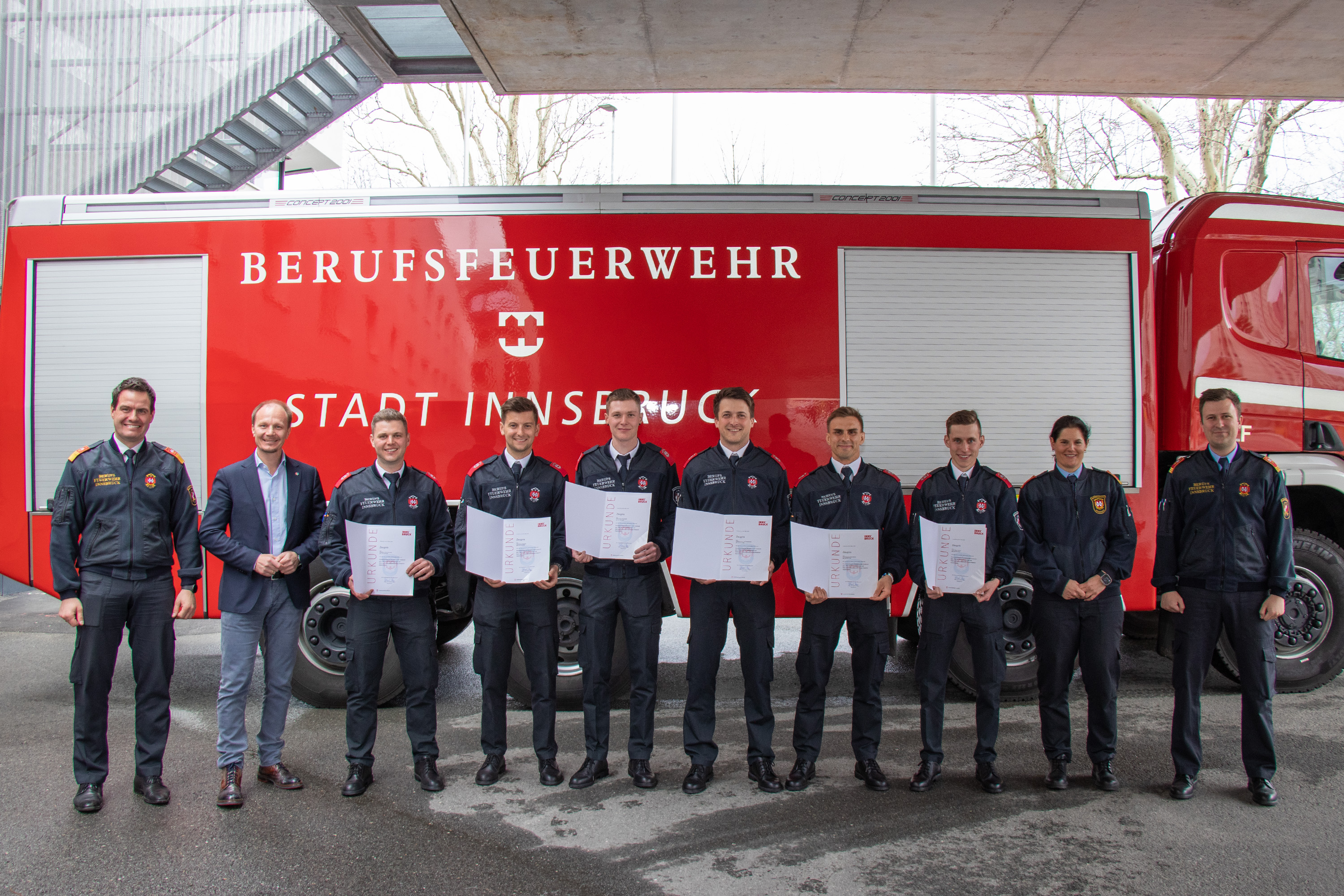 Bürgermeister Johannes Anzengruber (2. v. l.), Branddirektor Helmut Hager (l.) sowie die beiden Offiziere Maria Nuener und Ricardo Stauder (r.) gratulieren den Absolventen zum erfolgreichen Abschluss des Grundlehrgangs.