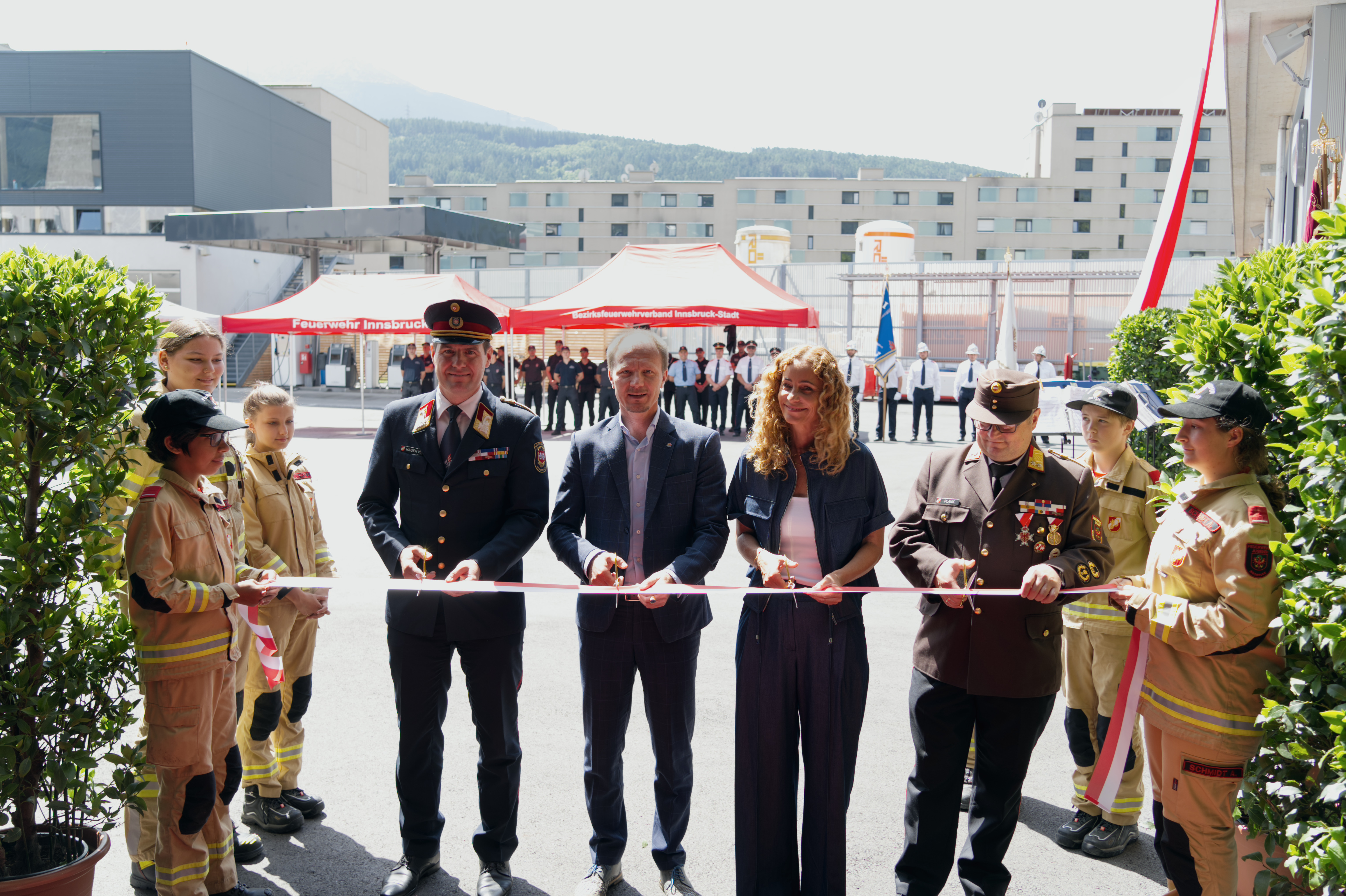 Landesrätin Eva Pawlata (4.v.r.), Bürgermeister Johannes Anzengruber (m.), Branddirektor Helmut Hager (4.v.l.) und Bezirks-Feuerwehrkommandant Helmut Plank (3.v.r.) schnitten das symbolische Band zur Eröffnung des Neubaus durch.
