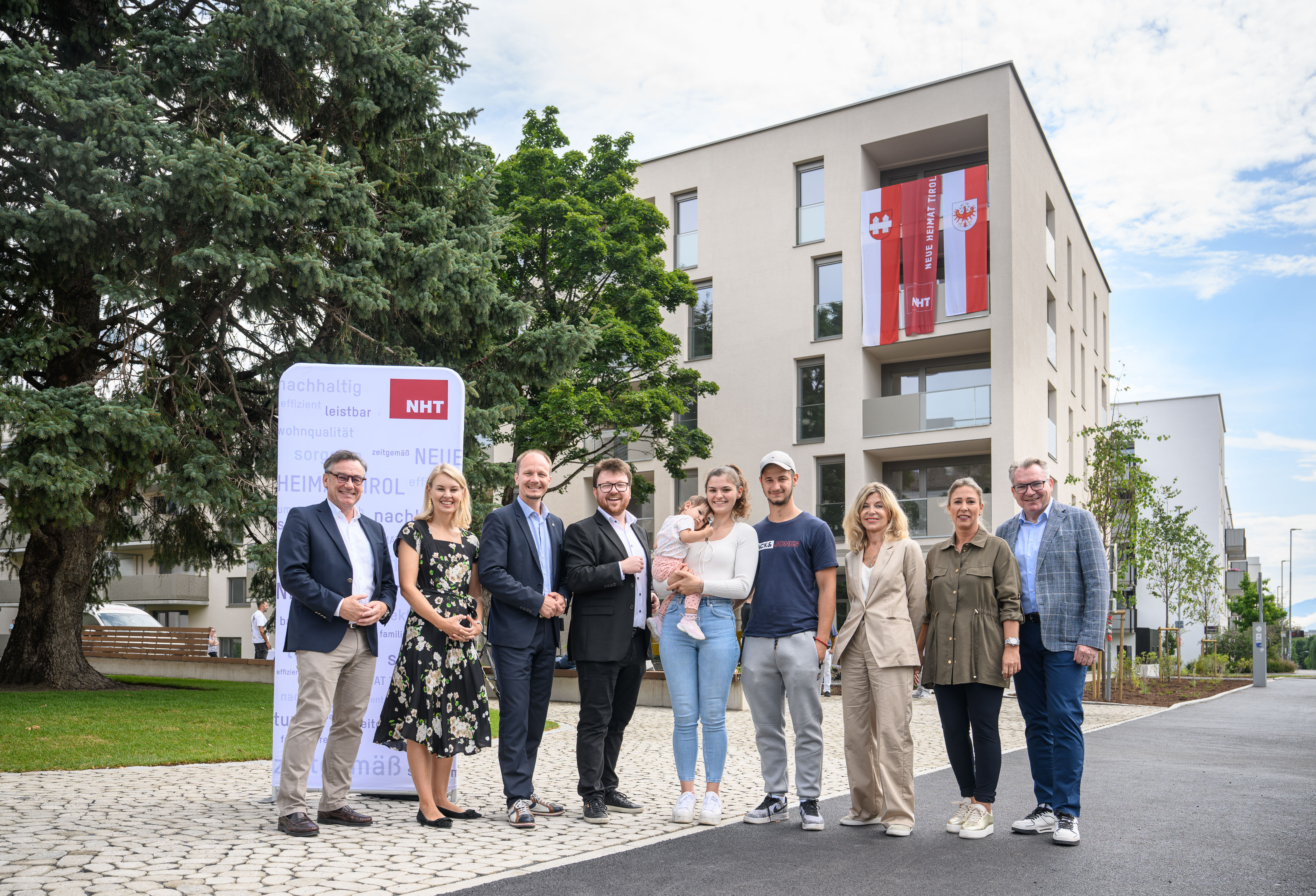NHT-/Stadtbau-Geschäftsführer Markus Pollo begrüßt mit Bürgermeisterstellvertreterin Elisabeth Mayr, Bürgermeister Johannes Anzengruber, Gemeinderat Benjamin Plach, Landtagsabgeordneter Daniela Meichtry, Stadträtin Mariella Lutz und NHT-Geschäftsführer Johannes Tratter Familie Ikic im neuen Zuhause.