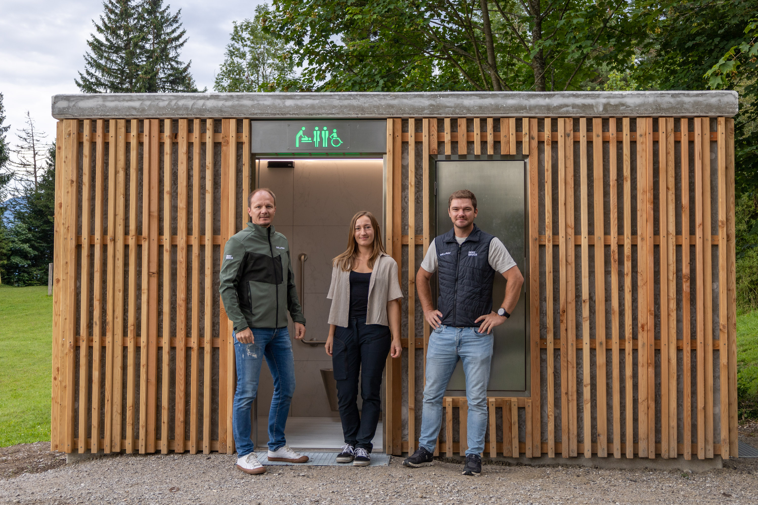 Bürgermeister Johannes Anzengruber, Amtsleiter Matthias Stang (r., Wald und Natur) sowie Charlotte Eggert (Referat Natur und Erholung) freuen sich über die neue, selbstreinigende WC-Anlage am Gramartboden.