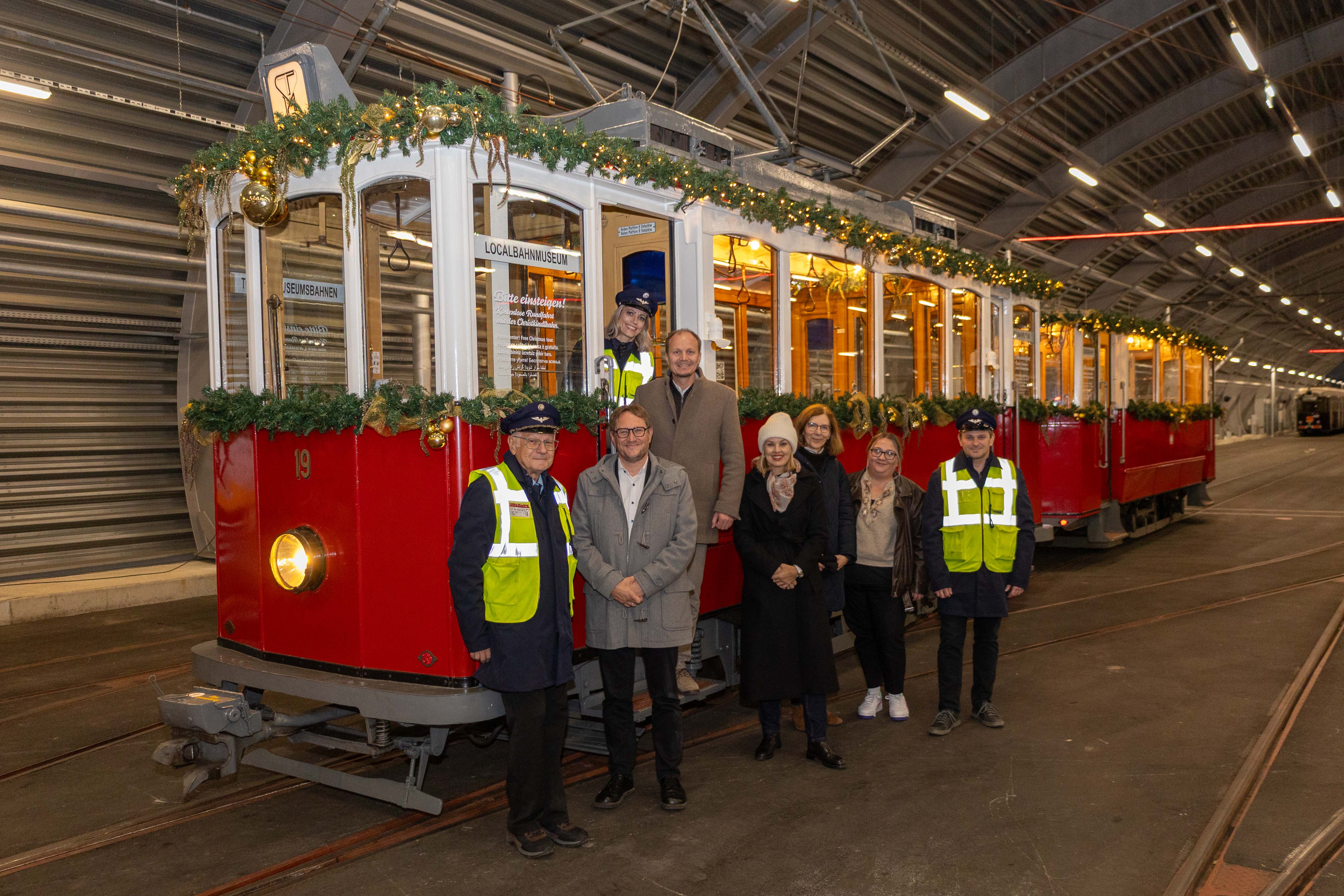 Alle einsteigen! Die Christkindlbahn bringt auch heuer wieder ein wenig Nostalgie auf die Schienen der IVB. Im Bild (v.l.n.r.): Walter Pramstaller (Vorsitzender Tiroler MuseumsBahnen), Geschäftsführer Ekkehard Allinger-Csollich (IVB), Bürgermeister Johannes Anzengruber, Vizebürgermeisterin Elisabeth Mayr, Amtsvorständin Martina Zabernig (Kinder, Jugend und Generationen) und Referentin Sarah Mair (Generationenförderung und Projekte) gemeinsam mit den FahrerInnen der heutigen Tour von den Tiroler MuseumsBahnen.