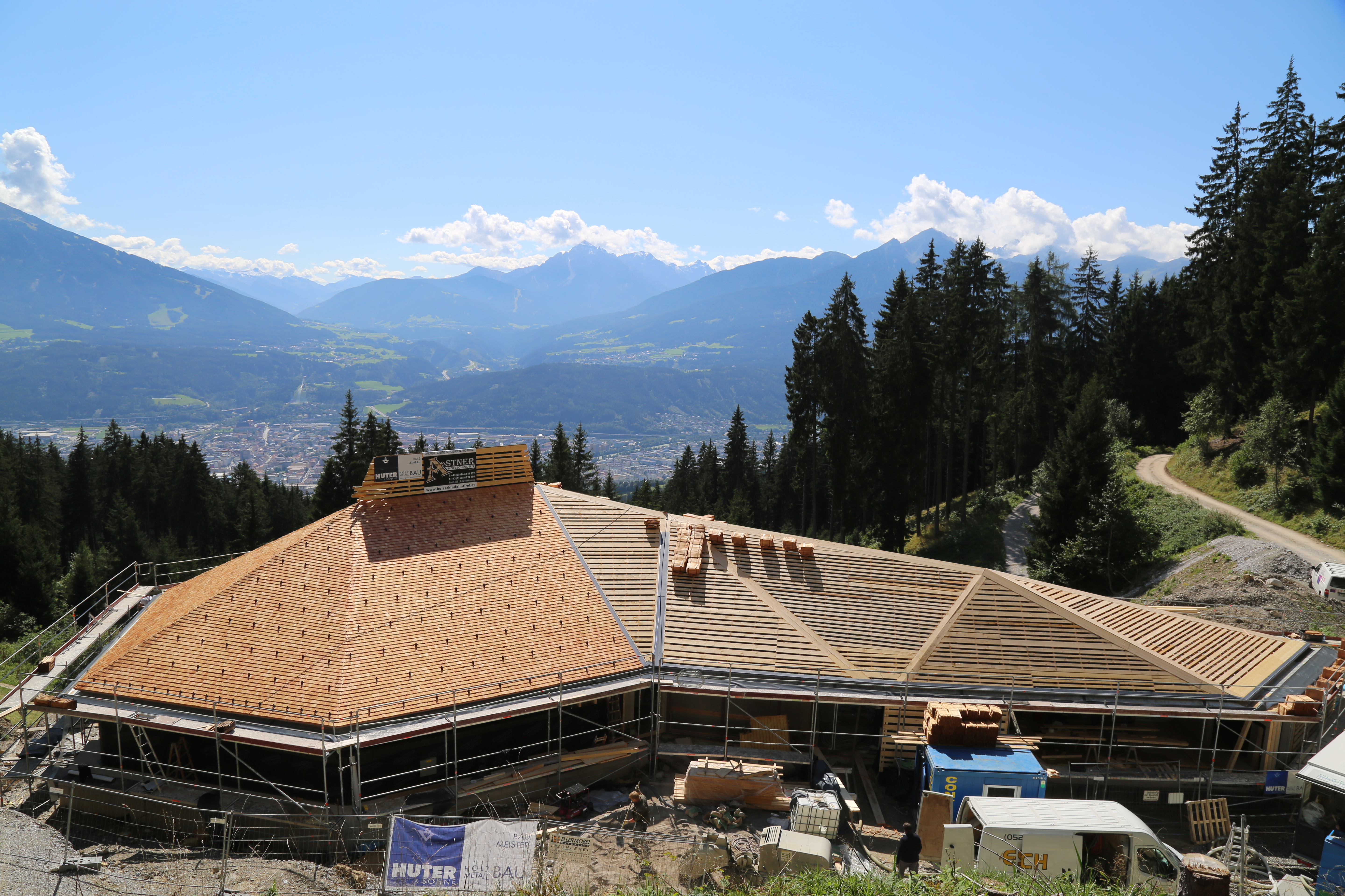 Der Bau der Umbrückler Alm schreitet zügig voran. Das Dach wird aktuell mit Lärchenschindeln eingedeckt und der Estrich wird im Innenraum verlegt. Weiters stehen die Holzwände kurz vor der Errichtung. Zwischenzeitlich kann schon der wunderschöne herbstliche Ausblick über die Tiroler Landeshauptstadt genossen werden.