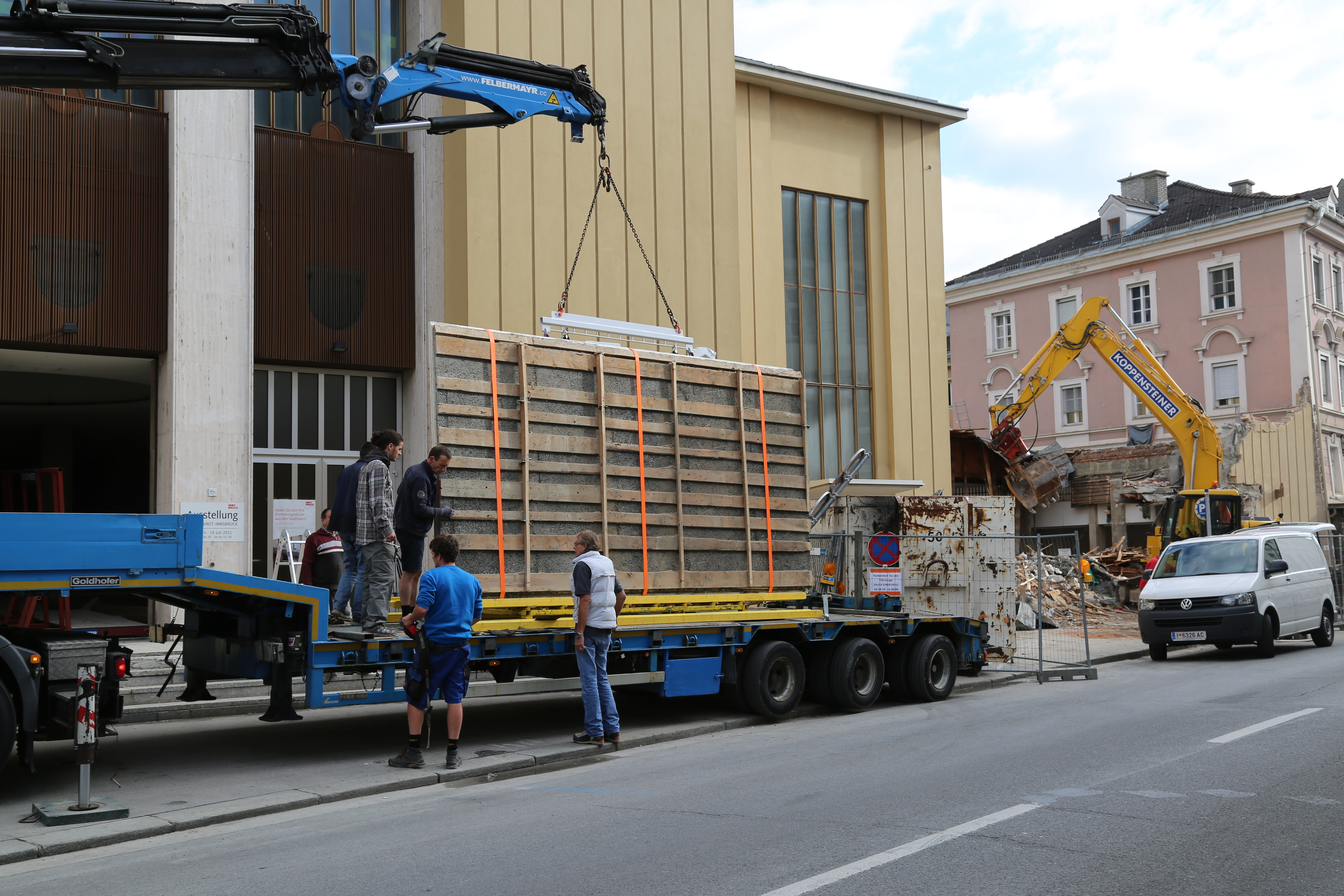 Der Spezial-LKW ist luftgefedert, damit eine sichere Fahrt zu den Lagerhallen in der Valiergasse garantiert ist. Im Hintergrund ist der Bagger bei den Abrissarbeiten der Stadtsäle zu sehen.