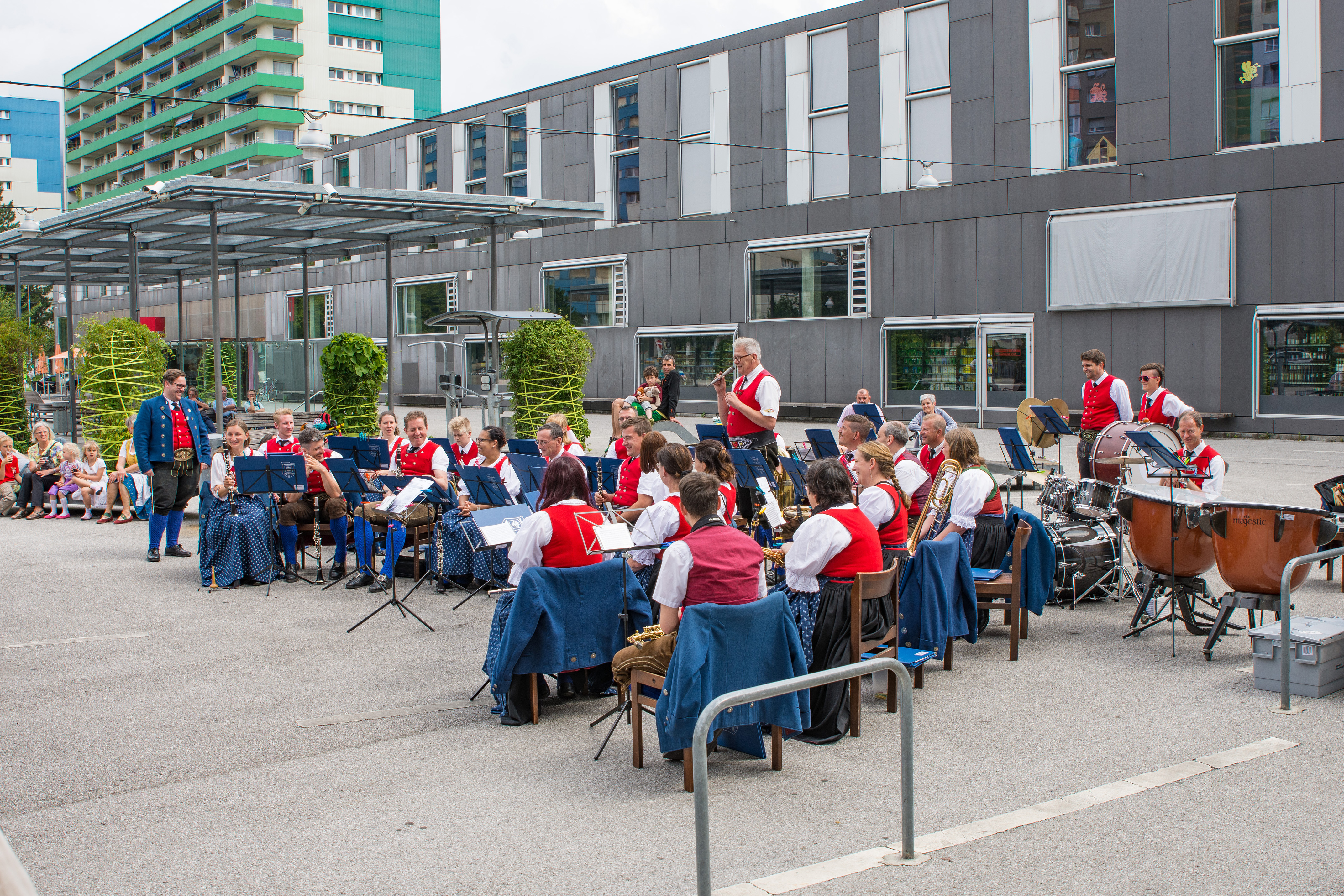 Vizebürgermeister Christoph Kaufmann eröffnete das Platzkonzert der Speckbacher Musikkapelle am DDr. Alois Lugger Platz. Gemeinsam mit der Pfarre St. Pius X und der Freiwilligen Feuerwehr Neu Arzl organisierte die Speckbacher Musikkapelle einen Frühschoppen im Olympischen Dorf .